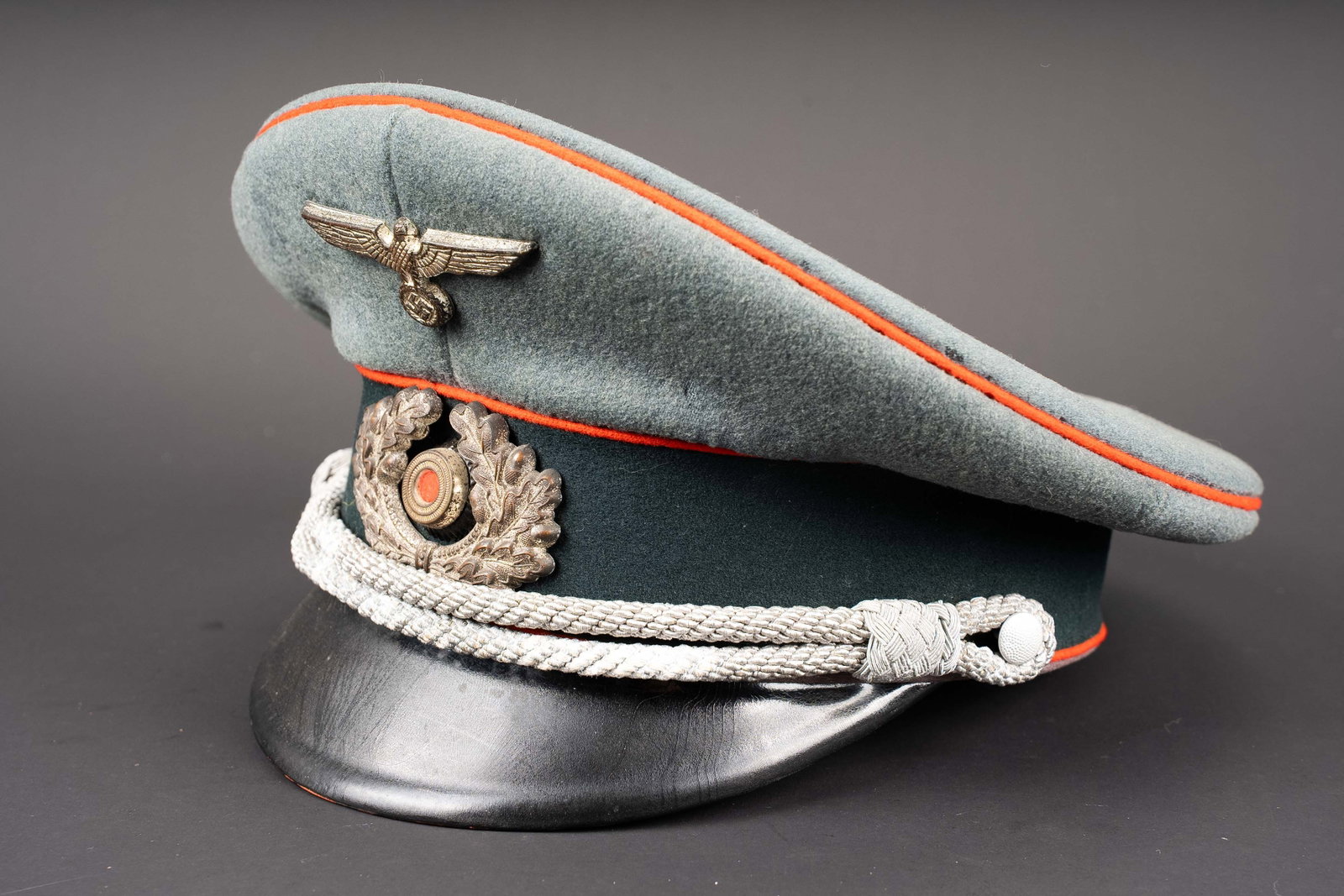 Casquette officier artillerie Heer. German Herr cap.: Casquette d officier de l artillerie de la Heer. En drap Feldgrau. Triple lisere rouge de l artillerie. Insignes metalliques. Les insignes n ont pas ete demontes afin de verifier les attaches. Jugulai