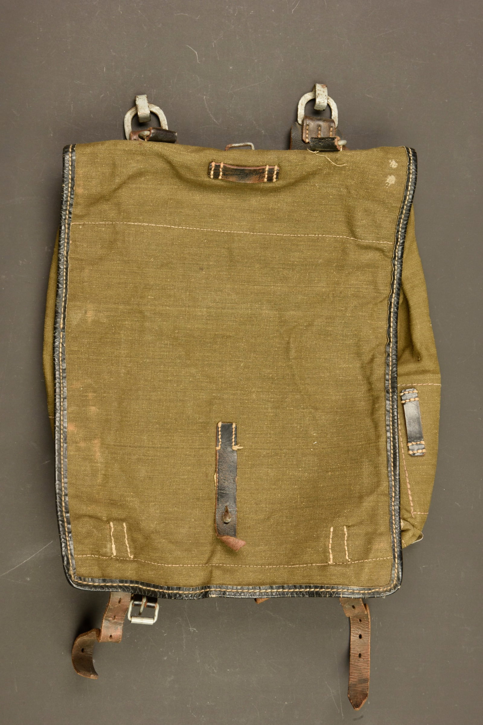 Sac a dos poils de vache. German Cowhide backpack.: Sac a dos poil de vache. En forte toile Feldgrau. Rabat depourvu de poils de vache. La majorite des sangles sont presentes. Les bretelles sont manquantes. Les parties metalliques sont majoritairement 