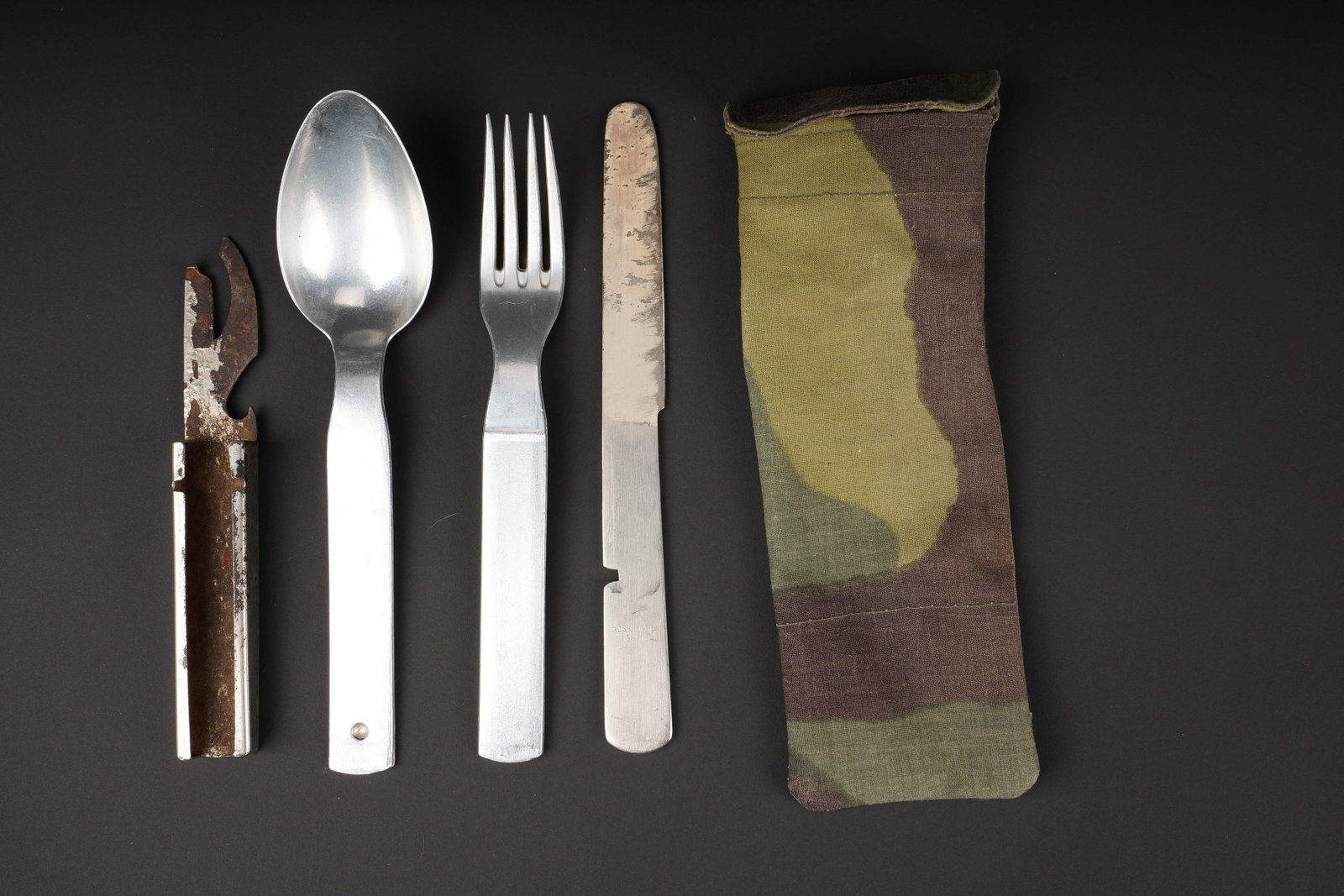 Couverts allemand. German cuttlery.: Couverts allemand. Modele encastrable. Comprenant un ouvre boite, un couteau, une fourchette et une grande cuillere. Bel aigle allemand. Housse fantaisie realisee dans une toile camoufle italienne. A