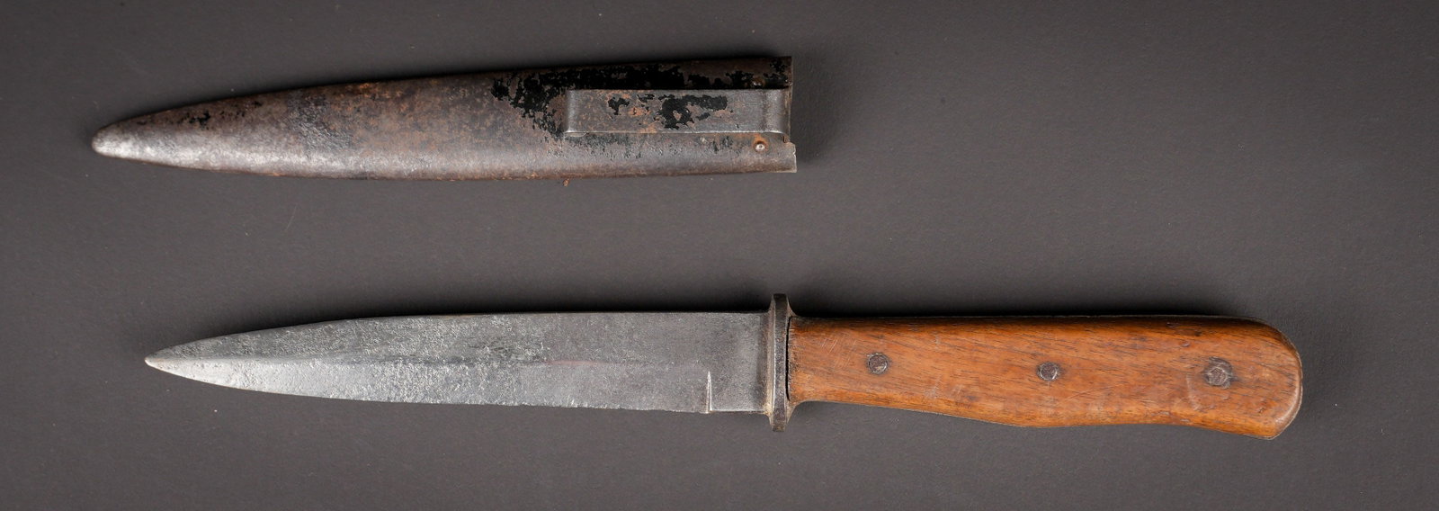 Couteau de botte. German knife.: Couteau de botte allemand. Manche en bois maintenu par trois rivets. Lame oxydee et nettoyee, reste de marquages visibles. Fourreau en metal, completement decape, attache complete. Entree du fourreau