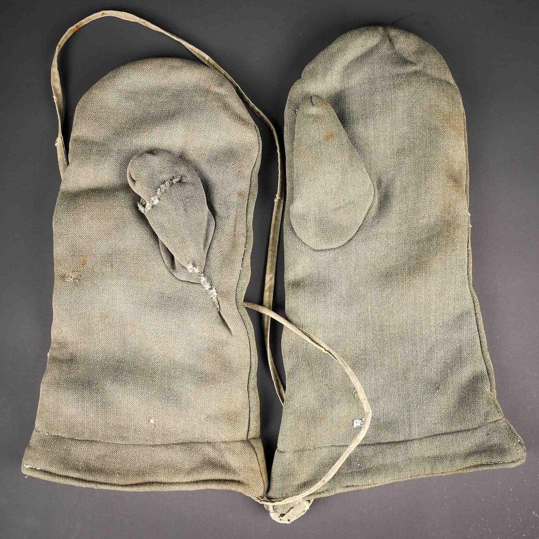 Moufle allemande. German winter gloves.: Paire de moufle allemande. Modeles reversible. En epais tissu gris reversible blanc. Les cordons sont presents. Les marquages sont illisibles. A noter une certaine usure et patine de la piece, ainsi