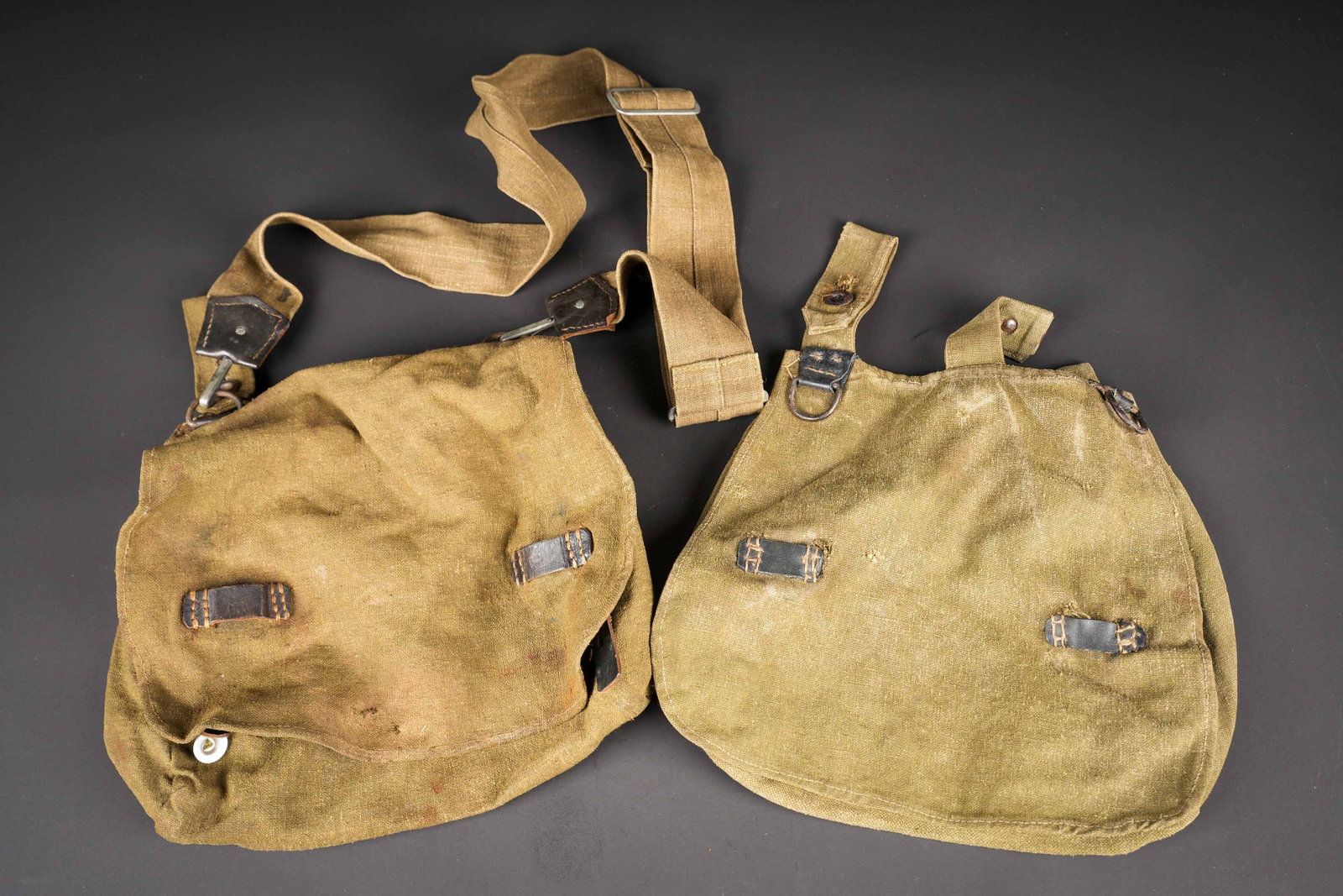 Sacs a pain allemand. German bread bag.: Sacs a pain allemand. Comprenant un sac a pain en tissu Feldgrau et cuir noir, nombreuses reparations visibles. Sans marquages visibles. Un sac a pain en toile Feldgrau et cuir noir, sans marquages