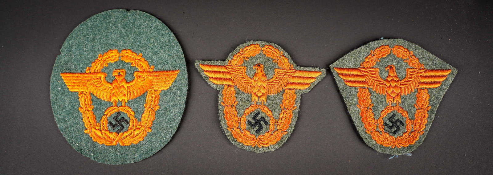 Insignes Gendarmerie. German Gendarmerie insignia.: Insignes Gendarmerie. Comprenant deux aigles de manche predecoupes brodes sur fond en drap gris vert. Dos des pieces double en tissu coton beige et bleue. Un aigle de manche complet, quelques traces d