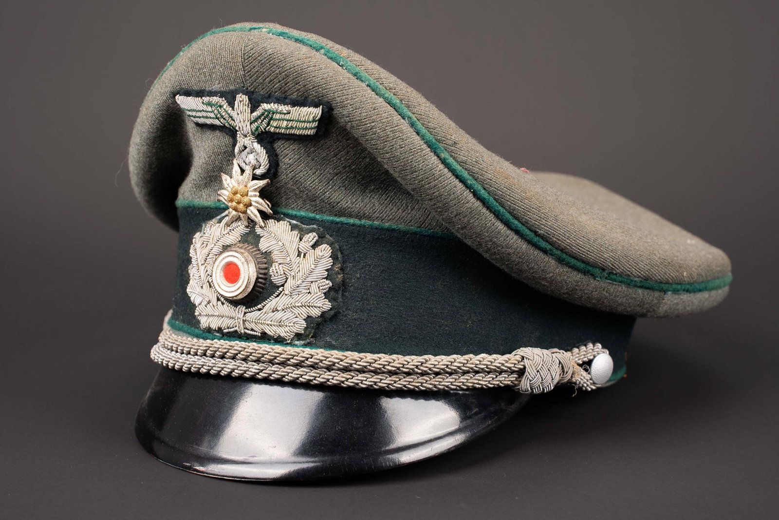 Casquette de Gebirgsjager. German mountain cap.: Casquette de Gebirgsjager. En drap Feldgrau. Triple lisere vert fonce des troupes de montagne. Bandeau en drap vert. Cocarde metallique. Feuilles de chene et aigle en cannetille argent, cousus main. E