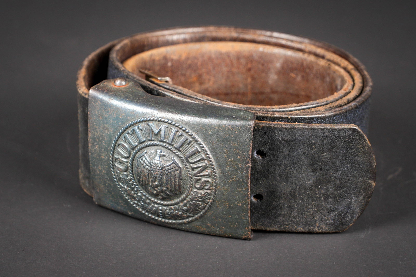 Ceinturon de la Heer. German belt and belt buckle: Ceinturon de la Heer. Ceinturon en cuir noir. Modele sans patte de reglage. Les perforations de reglage sont directement faites sur le ceinturon. Bouclerie en metal, oxydee. Taille 95. Boucle de
