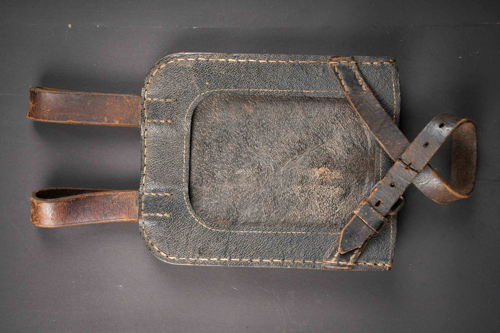 Housse de pelle droite. Straight shovel cover.: Housse de pelle droite. En carton compresse noir. Les passants au ceinturon sont presents. La sangle de fermeture est complete, mais reparee a l aide d une piece en cuir. Les marquages sont