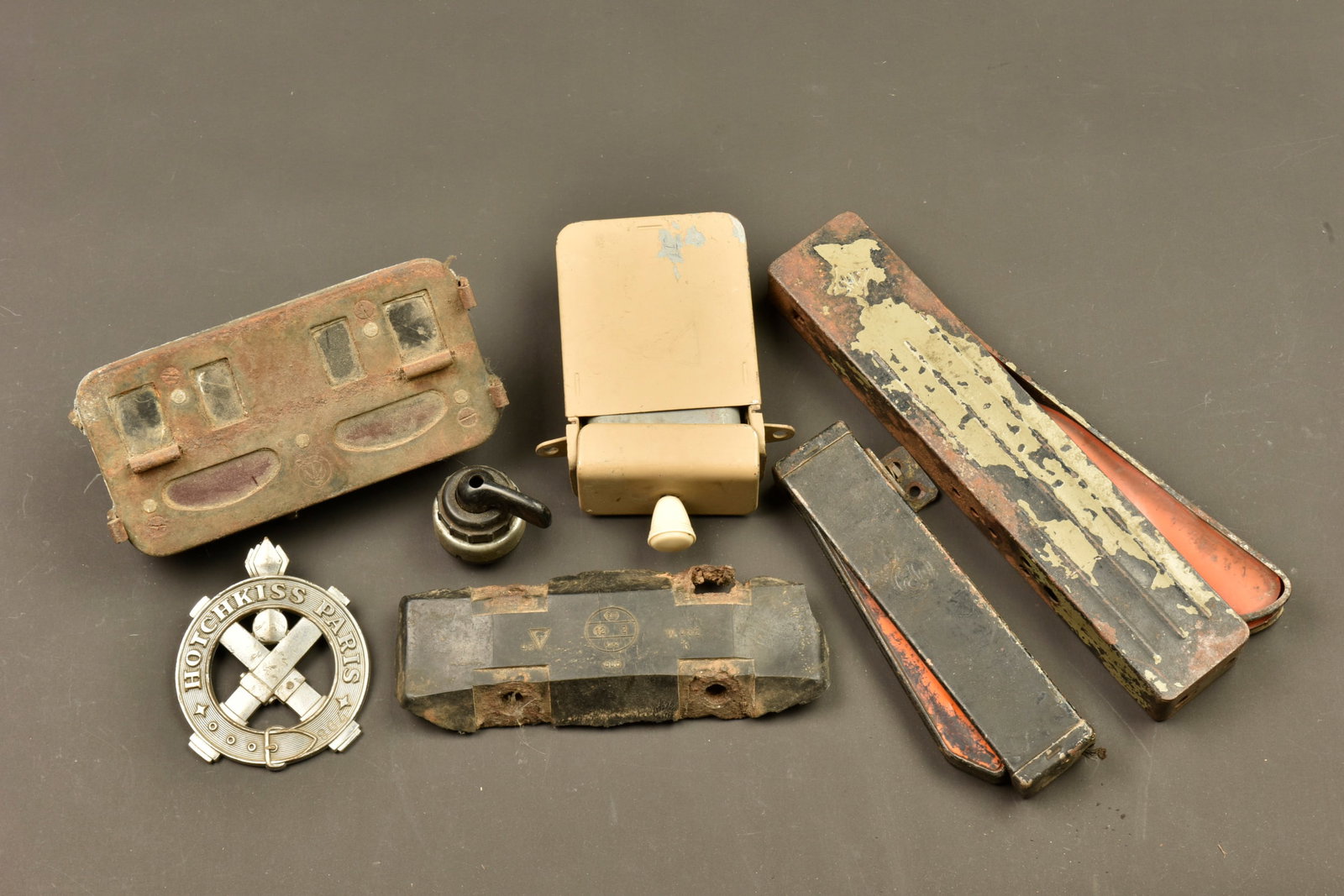Pieces de vehicule allemand. German vehicle parts.: Pieces de vehicule allemand. Comprenant un reste de patin en caoutchouc de SDKFZ. Une plaque de vehicule marquee Hotchkiss Paris, numero 864. Un bouton en bakelite sur son support metallique. Un