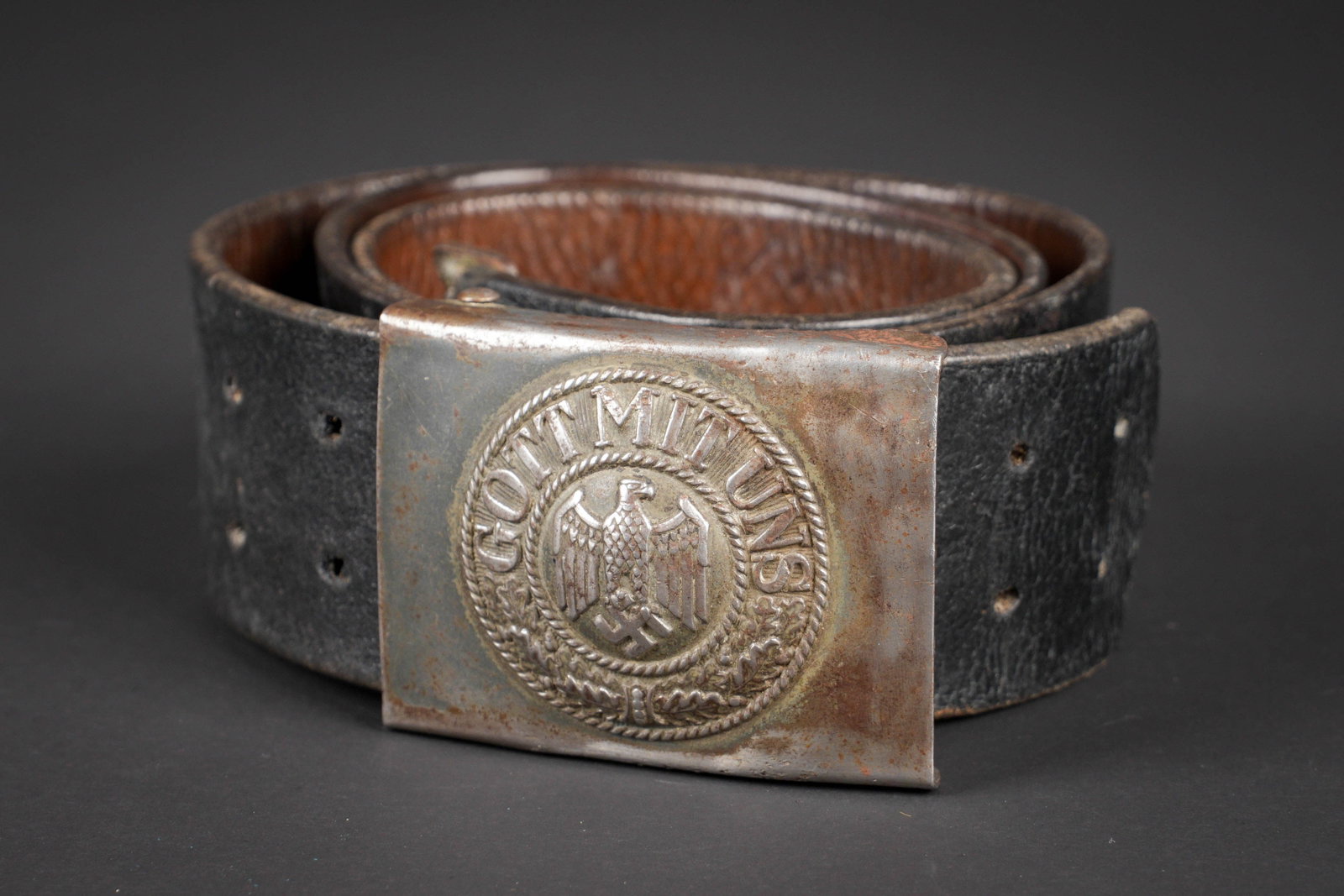 Ceinturon de la Heer. German belt: Ceinturon de la Heer. Ceinturon en cuir noir. Bouclerie en metal. Modele sans patte de reglage. Sans marquages visibles. Boucle de ceinturon en metal. Reste de peinture a 20%. Fortement nettoyee et