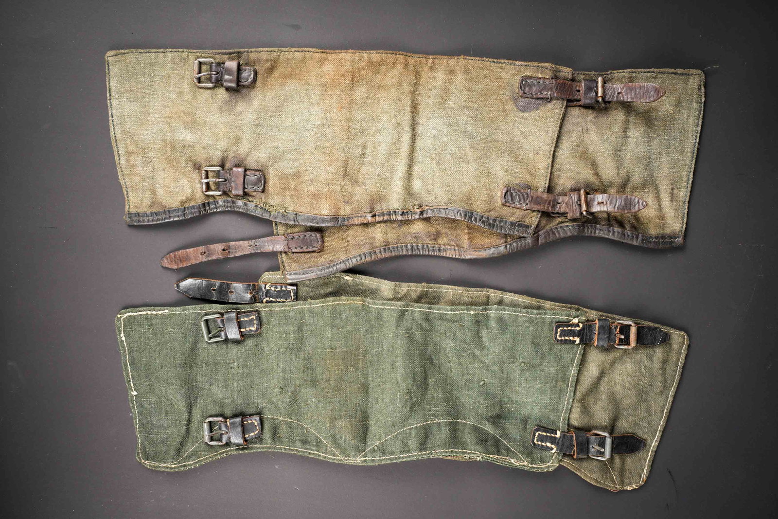 Guetres allemande. German gaiters.: Guetres allemande. Deux paires de guetres, non homogene. Les attaches sont presentes. Les marquages sont illisibles. A noter une certaine usure et patine des pieces, ainsi que quelques taches et