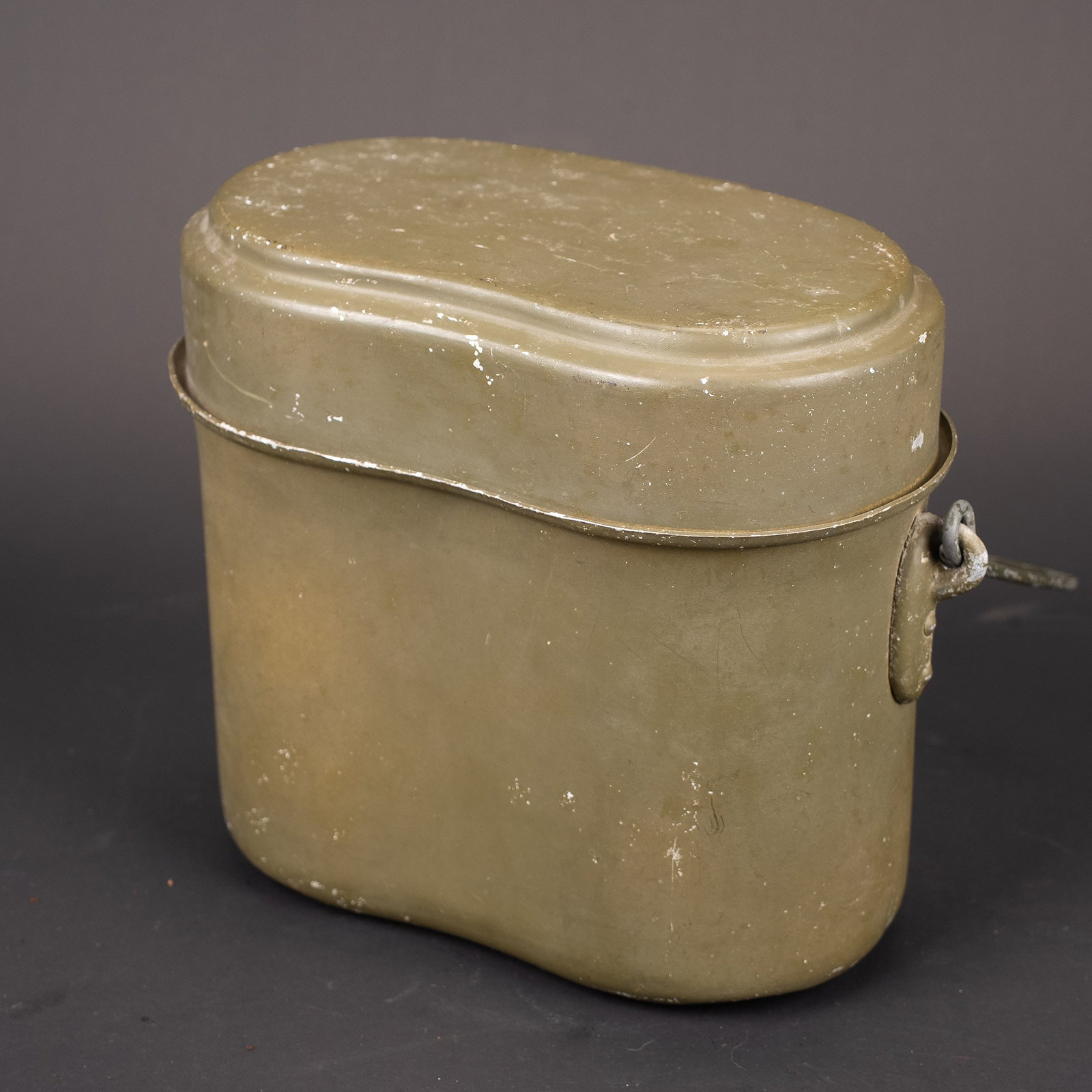Gamelle allemande. German mess tin: Gamelle allemande. En metal. Peinture Feldgrau a 95%. Poignee de transport en metal. Fabrication SMM 44 et SMM 43. A noter une legere usure et patine de la piece. Etat I-. German mess tin. Metal