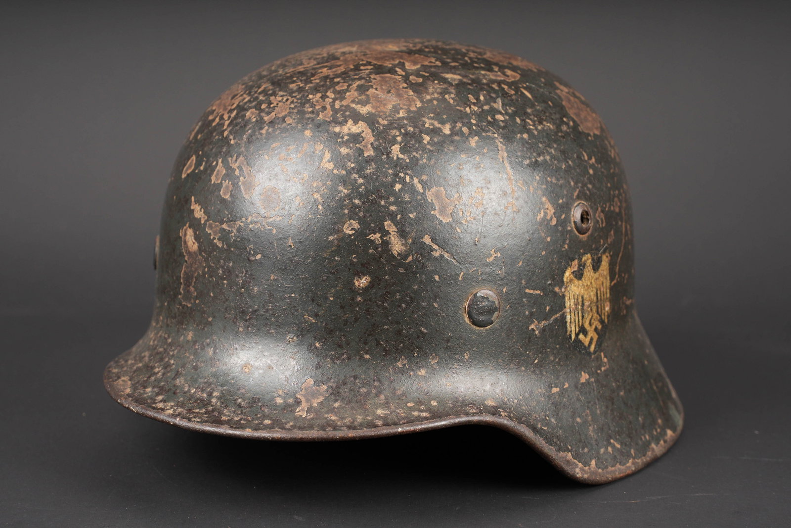 Coque de casque allemand. German helmet shell: Coque de casque allemand. Coque de casque M-40. Fabrication S64, numero de lot 23772. Coiffe absente. Cerclage complet avec ses rivets. Petit morceau de jugulaire present. Peinture exterieure tres