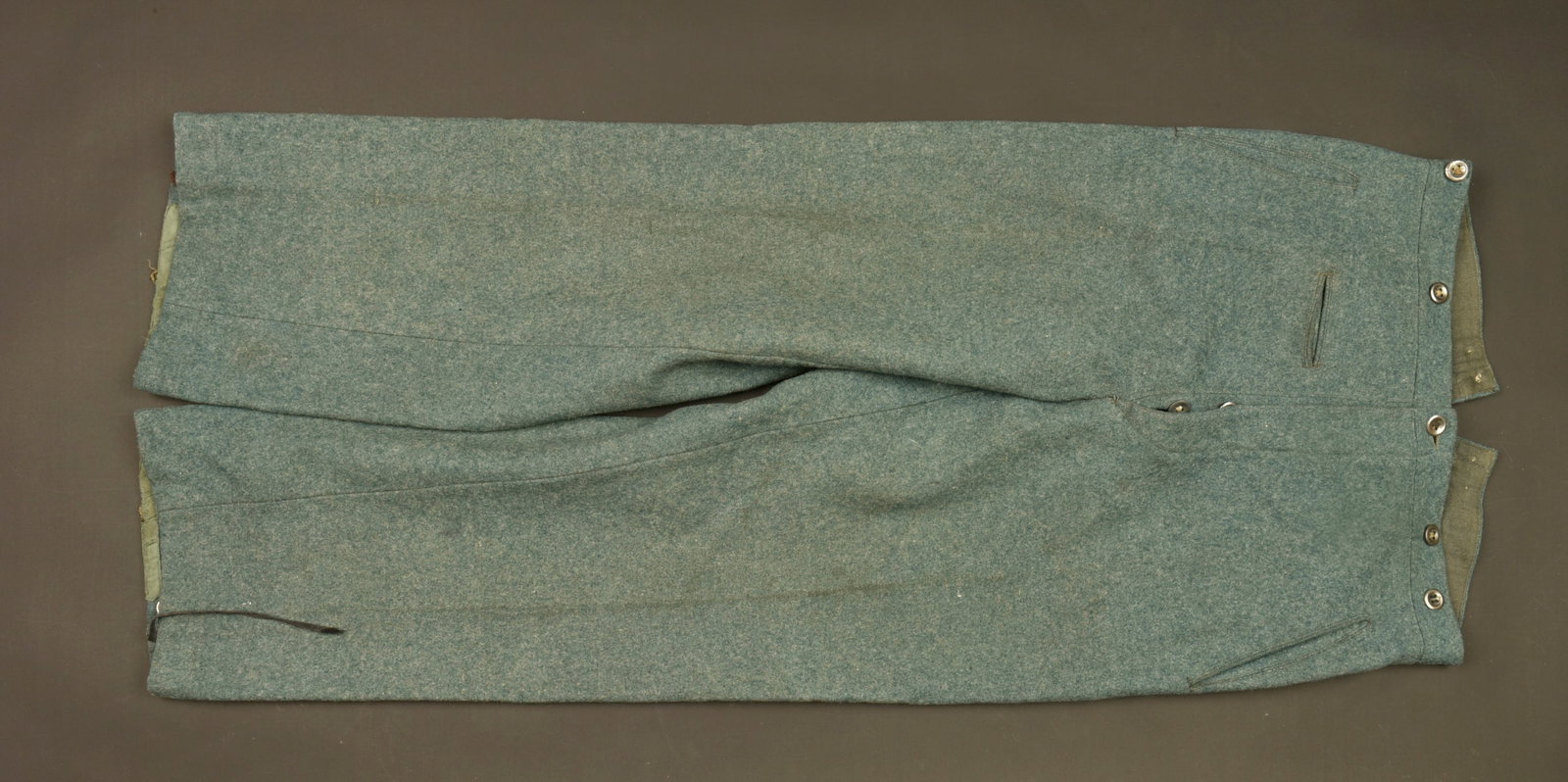 Pantalon Polizei. German Police trousers.: Pantalon Polizei. En drap gris/vert. Tous les boutons sont presents. Les cordons de serrage au bas des jambes sont incomplets. Interieur double en tissu coton gris, sans marquages visibles. A noter