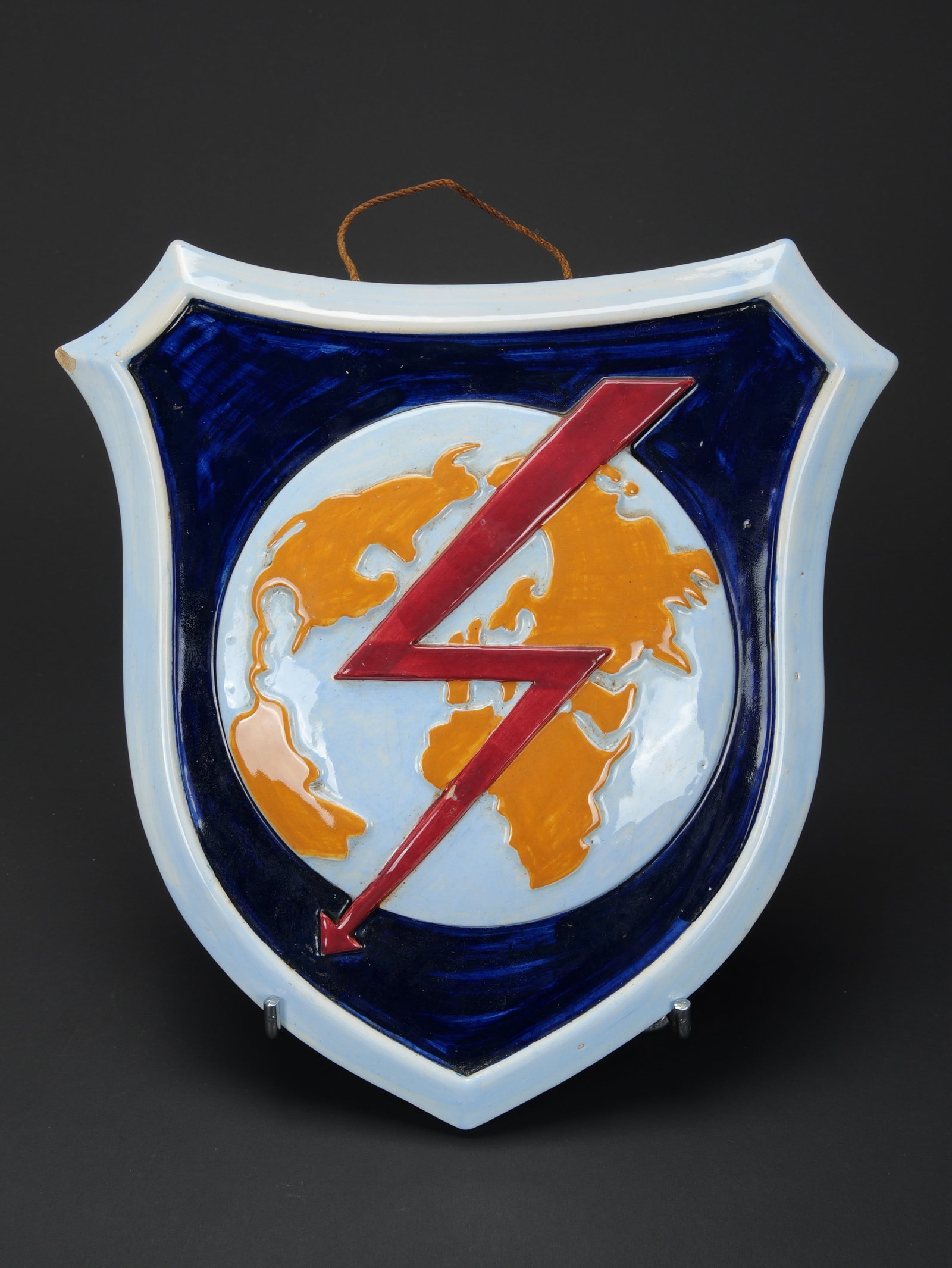 Ecu en faience de l abwehr. Abwehr faience plaque.: Ecu en faience de l abwehr ou des transmissions. En ceramique peinte. Insigne des transmissions de couleur rouge traversant le globe terrestre. Attache murale complete. Marquages au dos Kriegsweihnach