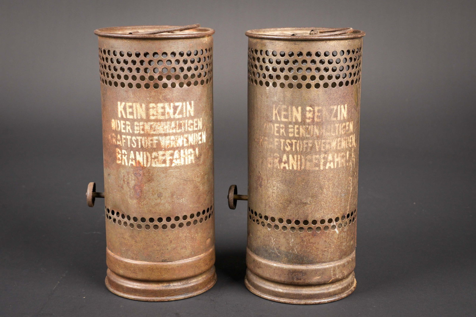 Rechauds allemand. German stove: Rechaud allemand. Deux pieces en metal. Toutes les pieces metalliques sont presentes. Marquages Kein Benzin. Un rechaud est partiellement tordu. A noter une certaine usure et patine des pieces. Etat I
