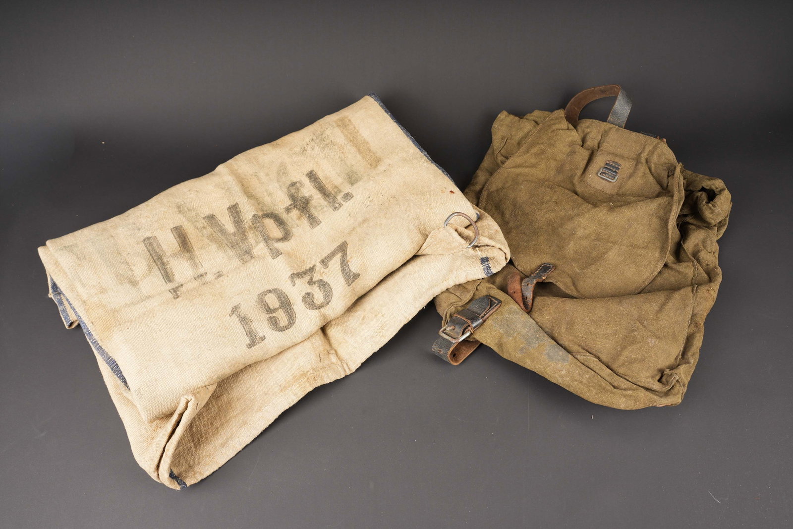 Equipements allemand. German equipment: Equipement allemand. Comprenant un sac a dos d allegement en toile Feldgrau et cuir noir. Les bretelles en cuir sont completes, ainsi que le cordon de serrage. Marquage RBNr 0/0499/0026. Un sac en
