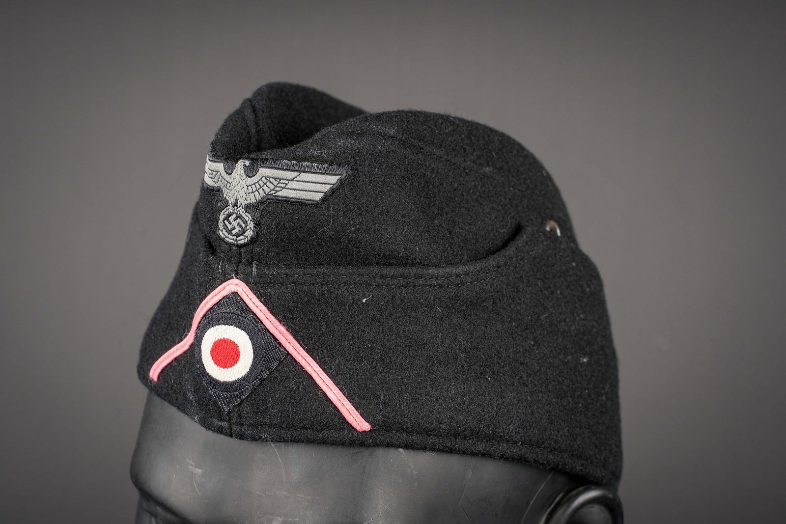 Calot Panzer. German Panzer garrison cap.: Calot Panzer. En drap noir. Deux aeration. Aigle Bevo cousu machine. Cocarde Bevo cousue machine. Soutache rose des unites Panzer. Interieur double en tissu coton gris. Marquage Kappenfabrik Wien.
