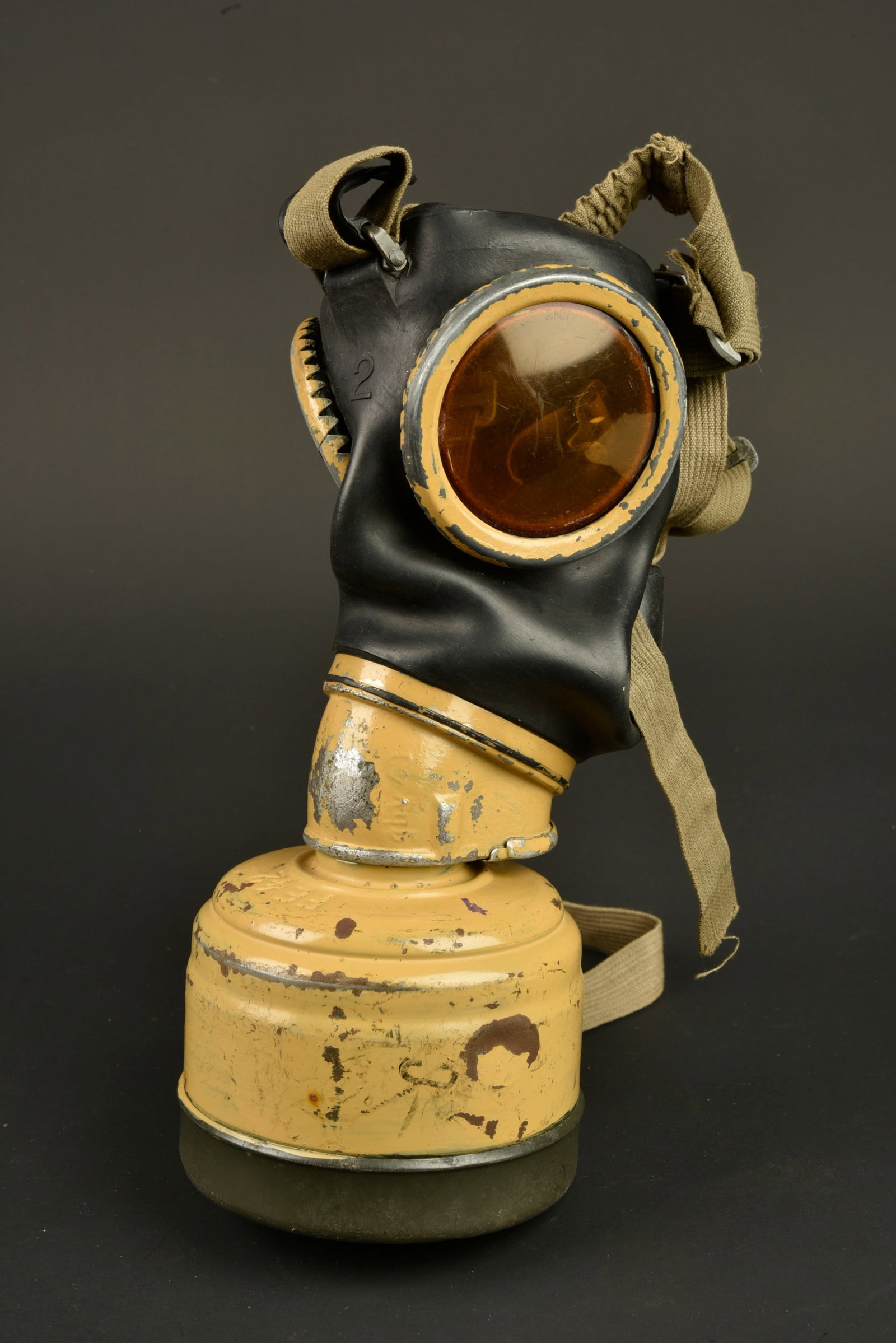 Masque anti-gaz allemand. German gas mask.: Masque anti-gaz allemand. En caoutchouc noir, taille 2. Toutes les sangles sont presentes. Les parties metalliques sont recouverte d une peinture jaune sable. Filtre FE42 complet disposant egalement