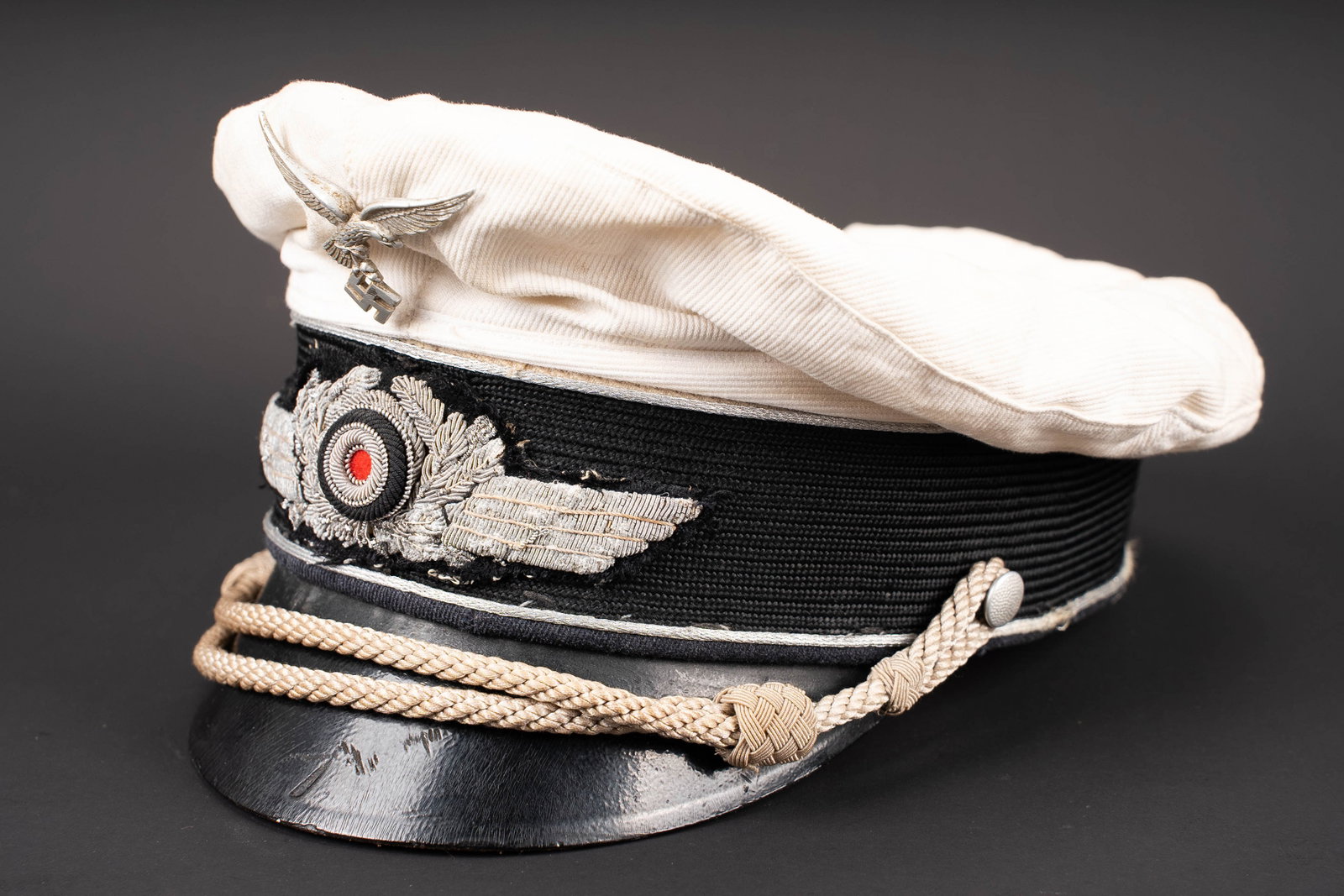 Casquette officier Luftwaffe. Luftwaffe officer?s visor cap.: Casquette d officier de la Luftwaffe. Modele estival. Bandeau en mohair noir. Coiffe amovible blanche en nid d abeille coton blanc. Aigle du premier type en metal. Cocarde et feuilles de chene en