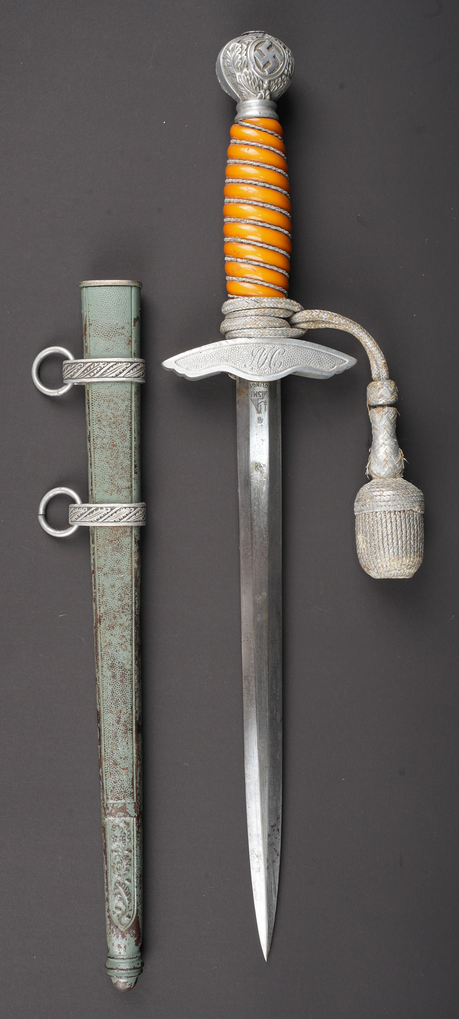 Dague Luftwaffe. German luftwaffe dagger: Dague de la Luftwaffe. Garniture en metal couleur argent. Poignee en cellulod orange. Filigrane complet. Dragonne nouee de maniere reglementaire, fortement usee. Fourreau tres bossele et recouvert d