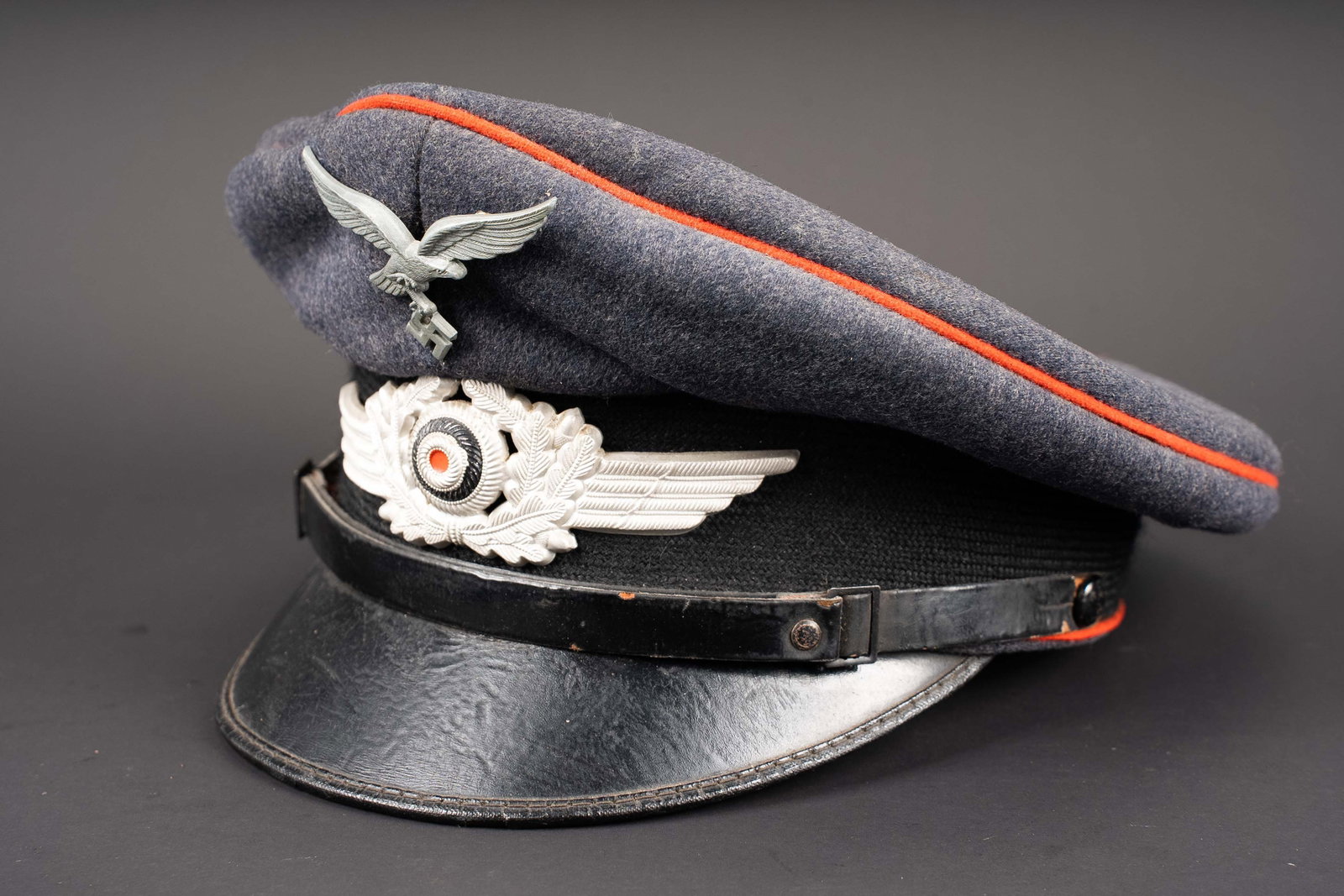 Casquette de la Flak. German anti-aircraft cap.: Casquette de sous-officier de la Flak. En drap gris/bleu. Triple lisere rouge de la Flak. Bandeau en mohair noir. Insignes metalliques. Les insignes n ont pas ete demontes afin de verifier les