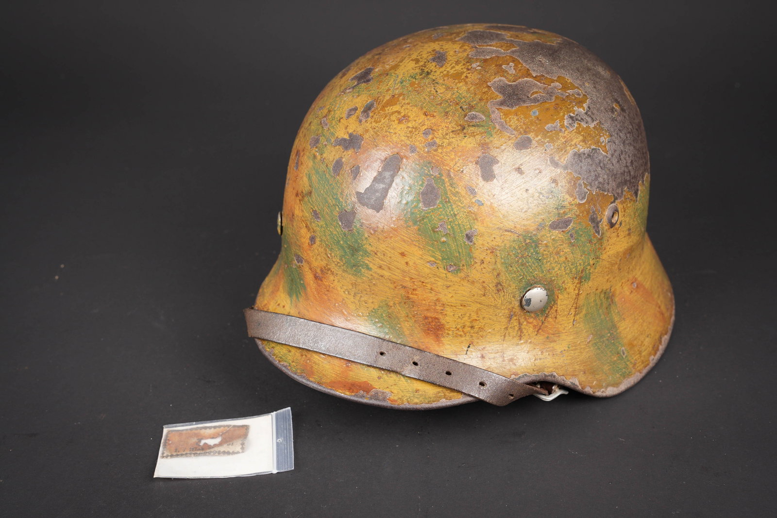 Casque de la Luftwaffe camoufle. Camouflaged Luftwaffe helmet.: Casque de la Luftwaffe camoufle. Coque de casque M35. Fabrication ET 64, numero de lot 3875. Peinture camoufle trois tons (sable/ocre/vert) a 70%. Realisation du camouflage au pinceau. Coiffe en cuir