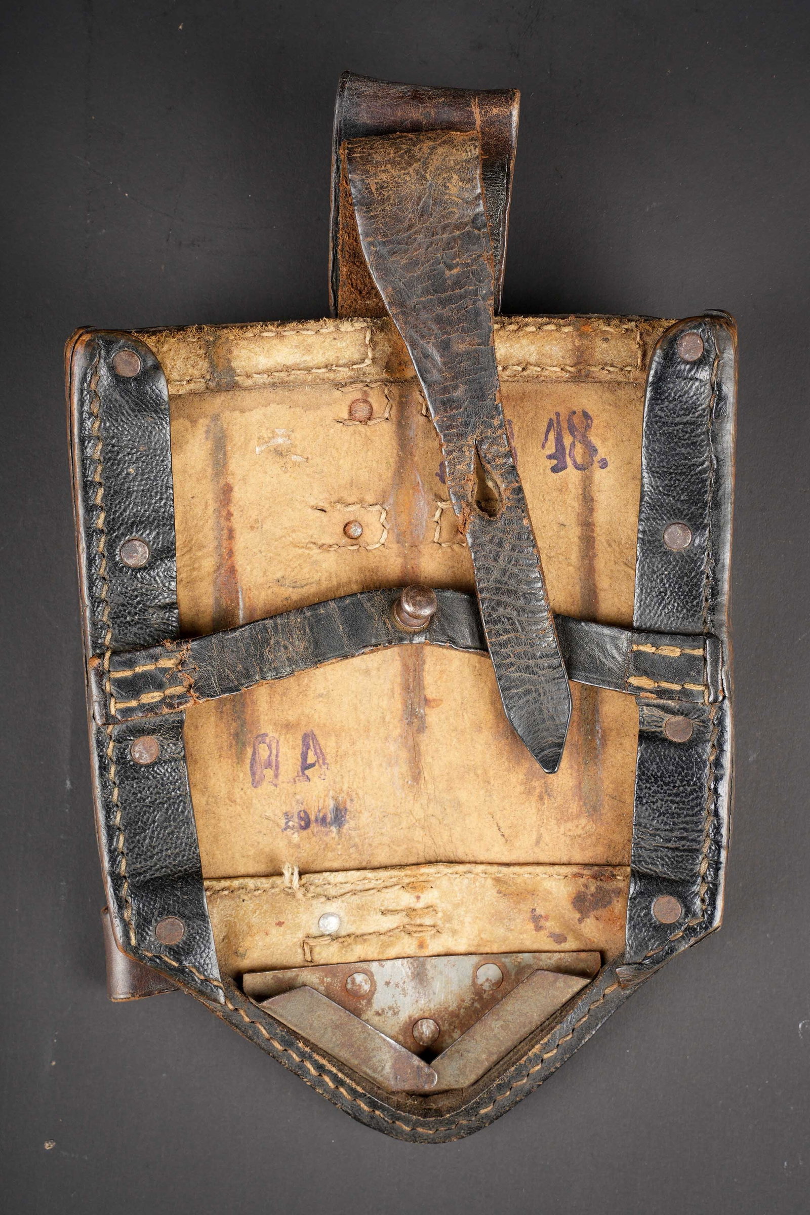 Housse de pelle pliante. Folding shovel cover.: Housse de pelle pliante. En carton compresse noir. Renfort en metal. La sangle de fermeture est fonctionnelle. Le passant au ceinturon est complet. Marquages JH 18 et RA 1942. A noter une certaine