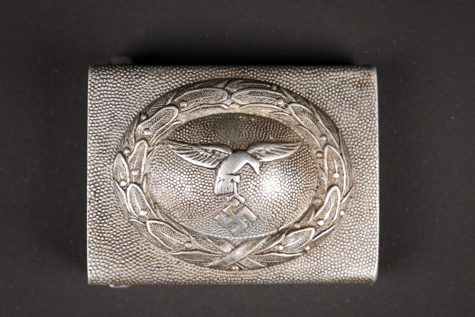 Boucle de ceinturon Luftwaffe. German Luftwaffe belt buckle.: Boucle de ceinturon de la Luftwaffe. En aluminium. Partie centrale tres bombee. Aigle de la Luftwaffe du premier type. Ardillons complets. Sans marquages visibles. A noter une certaine usure et