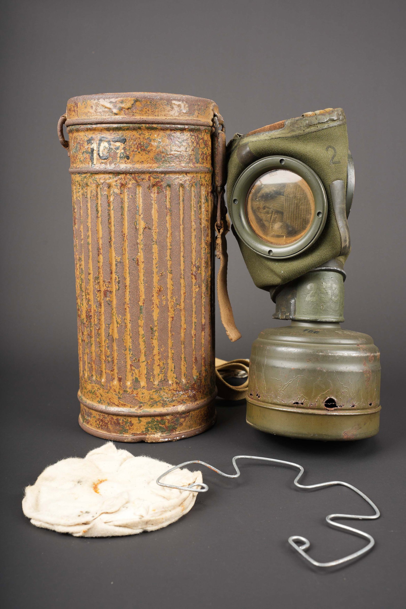 Masque anti-gaz camoufle. German Camouflaged gas mask.: Masque anti-gaz camoufle. Boitier long. Oxyde. Peinture jaune sable a 40%. Toutes les sangles sont presentes, mais d un modele different. Reste d un numero 107 peint a la peinture noire et blanche,
