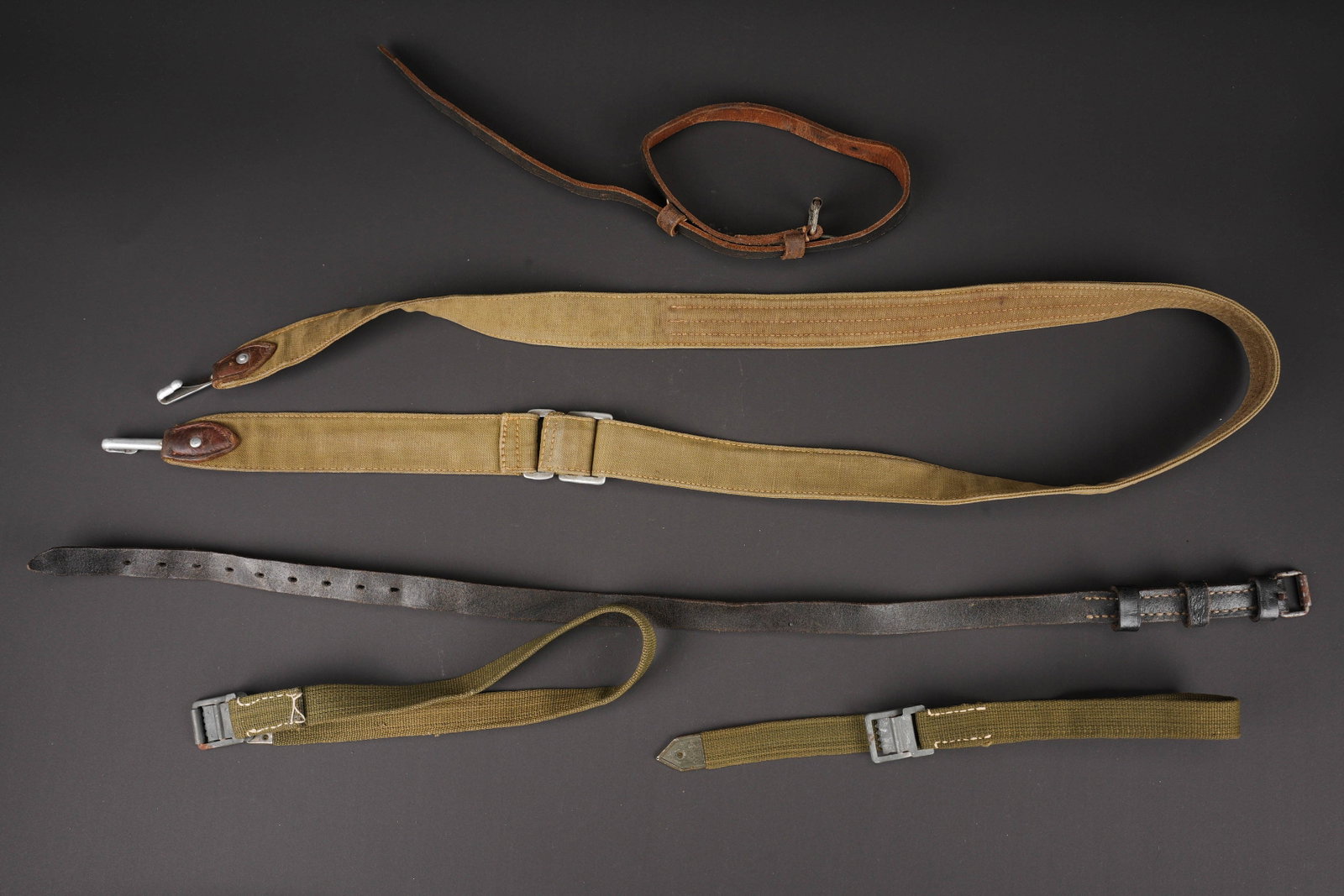 Sangles allemande. German straps.: Sangles allemande. Comprenant deux sangle en toile Feldgrau, boucleries portant les marquages LUX. Une sangle en cuir complete, sans marquages visibles. Une sangle de sac a pain en toile Feldgrau,