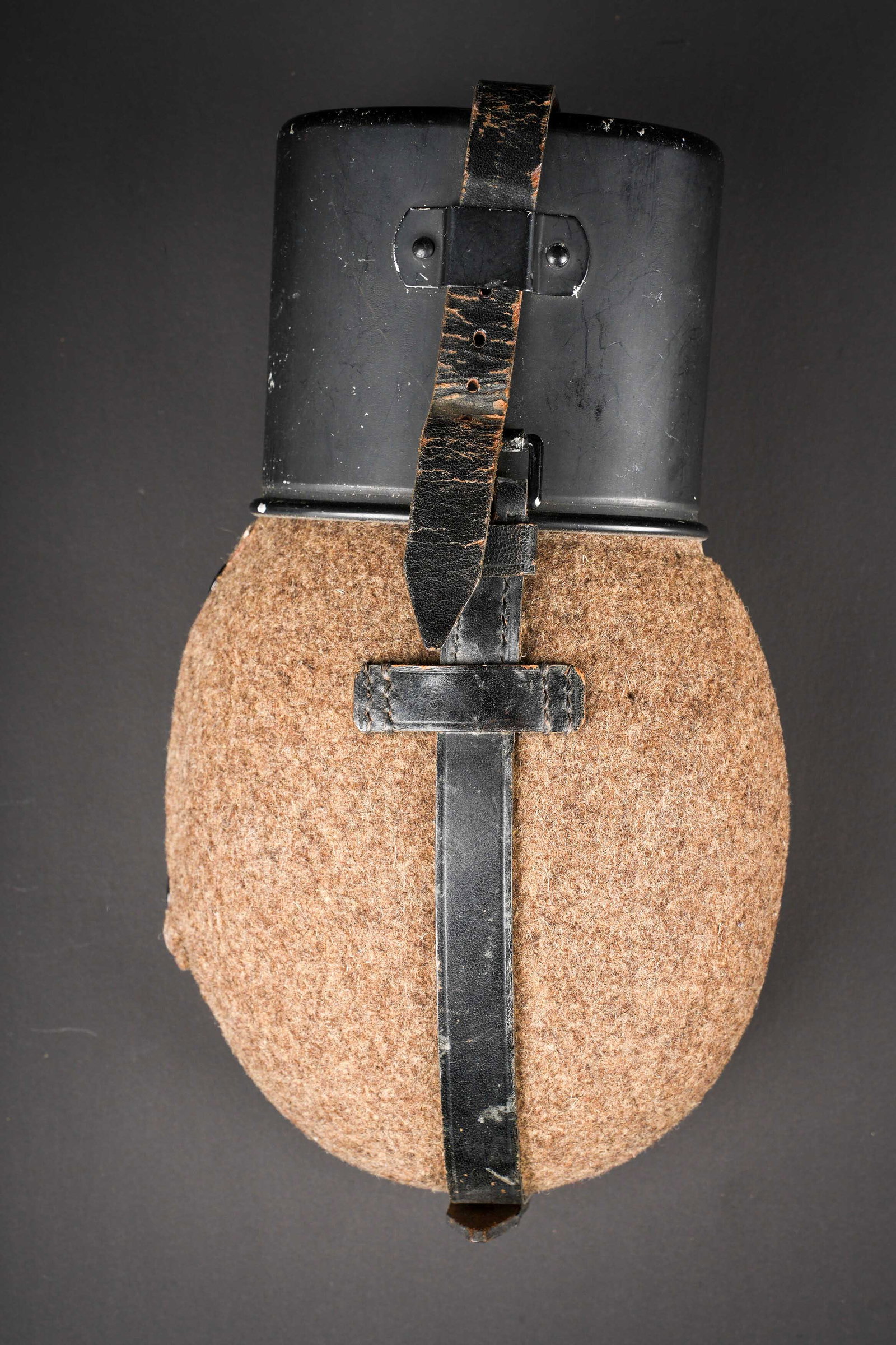 Gourde allemande. German Canteen: Gourde allemande. En aluminium. Fabrication SMW 34, bouchon en aluminium portant le meme marquage. Housse en feutrine marron. Les boutons pressions sont fonctionnelles. Harnais en cuir marron.