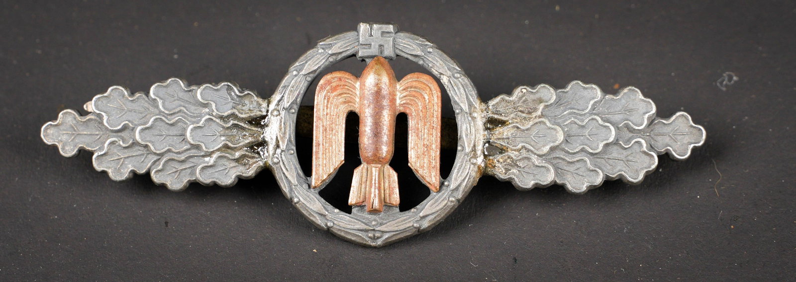 Frontluftspange. German Front Flight Clasp: Frontluftspange. En metal. Couleur argent, partie centrale couleur bronze. Les ailes ont ete cassees et recollees avec des renforts en metal. Attache complete. Fabrication FABL. A noter une certaine u