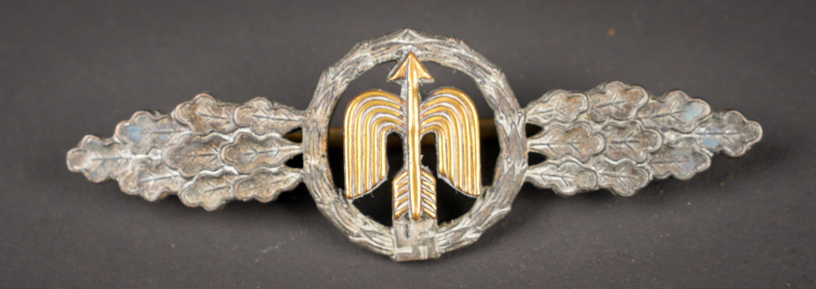 Frontluftspange. German Front Flight Clasp: Frontluftspange. En metal. Couleur argent, partie centrale couleur or. Fabrication en deux parties. Attache complete. Fabrication illisible. A noter une certaine usure et patine de la piece. Etat