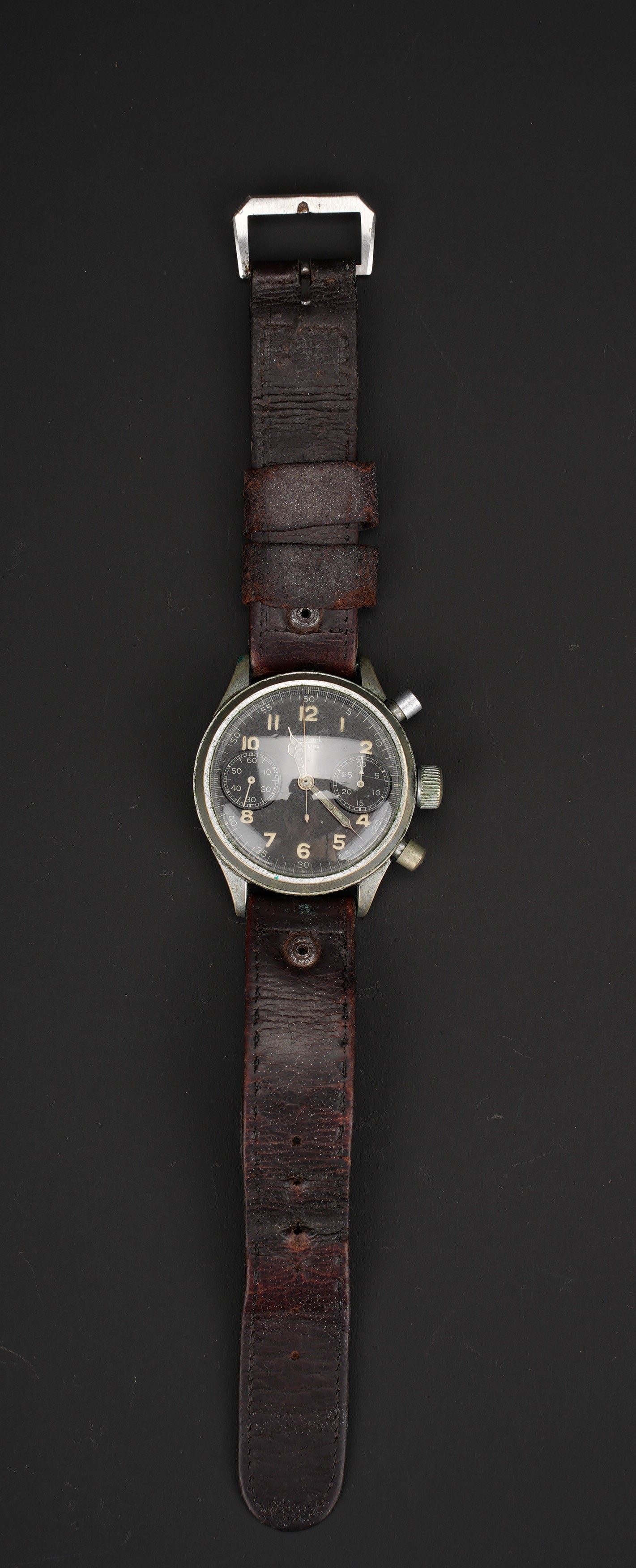 Montre Hanhart. Geman Hanhart stopwatch.: Montre de vol Hanhart. Cadran de couleur noir. Deux boutons poussoirs. Les aiguilles sont presentes. Fabrication Hanhart. Fonctionnelle. Bracelet en cuir complet avec son attache a ardillon.
