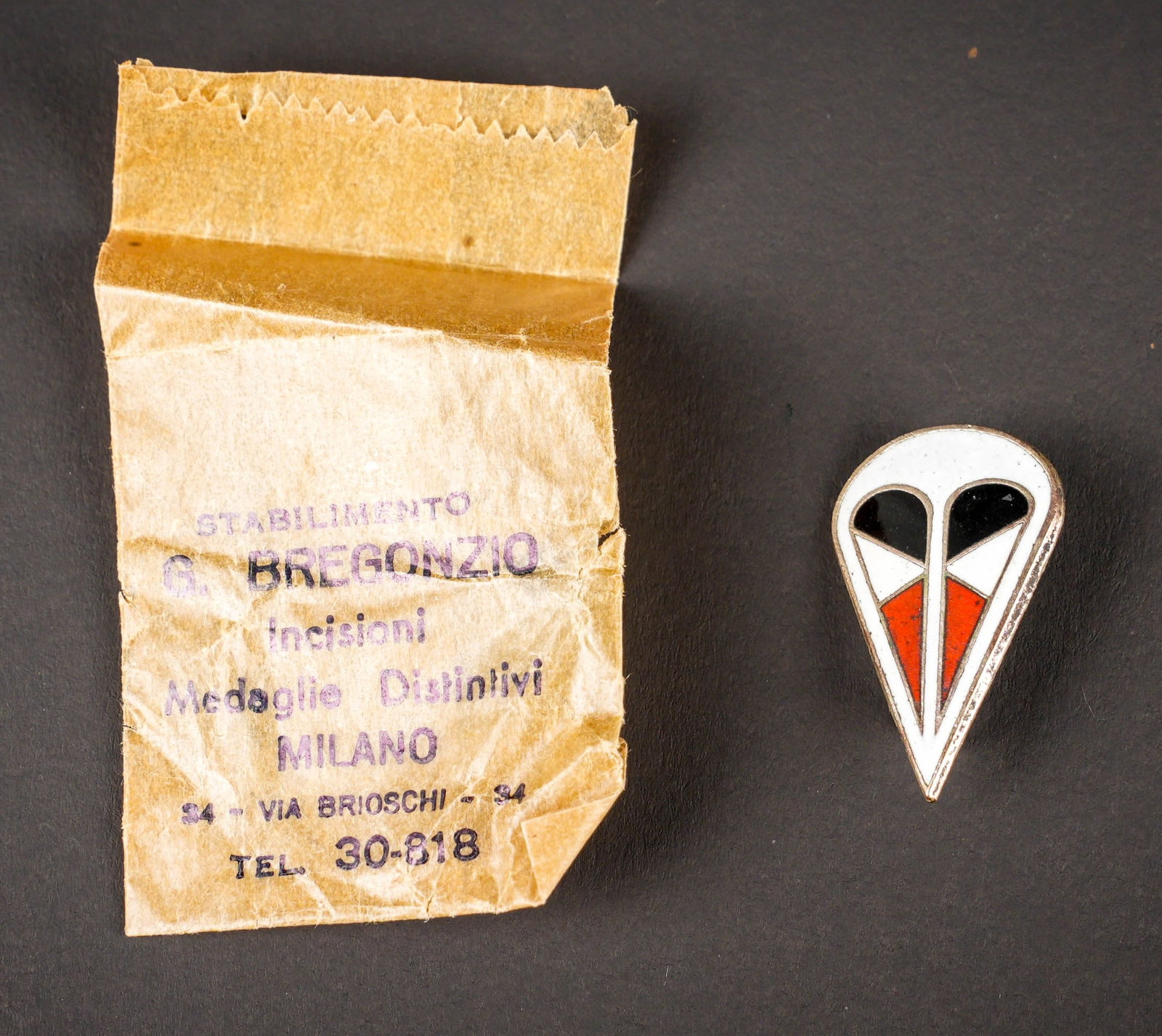 Insigne de coiffure parachutiste. German Paratrooper cap insignia.: Insigne de coiffure parachutiste. Insigne en metal emaille de la premiere divisons parachutiste, attache complete. Sachet present mais abime, marque Stabilimento G Bregonzio Incisioni Medaglie