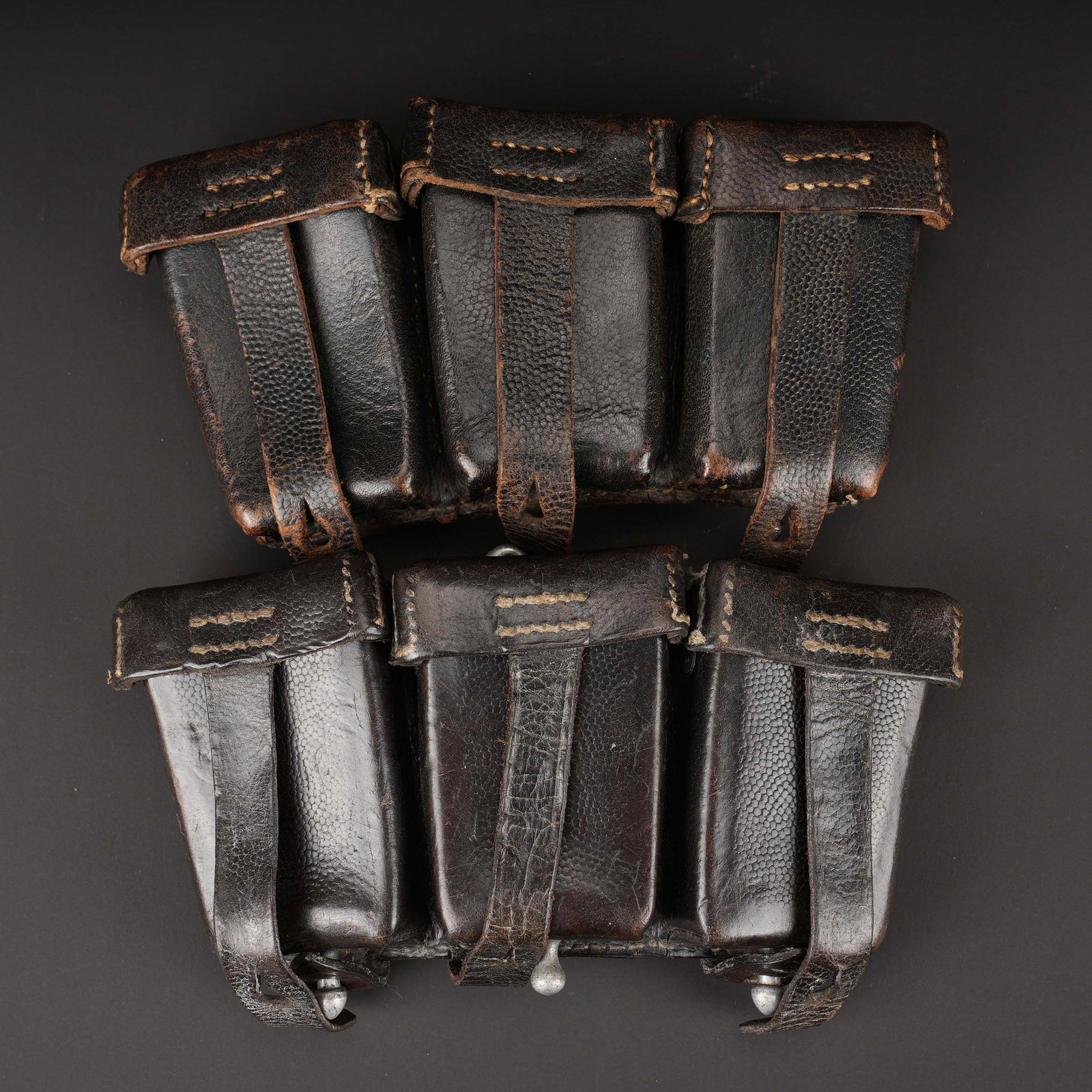 Cartouchieres de Mauser 98K. Mauser 98K ammunition pouches.: Cartouchieres de Mauser 98K. Paire non homogene en cuir grenele noir. Toutes les sangles sont presentes, ainsi que les anneaux metallique. Fabrication 0/0676/0028 C Harti Le Perreux, fabrication franc