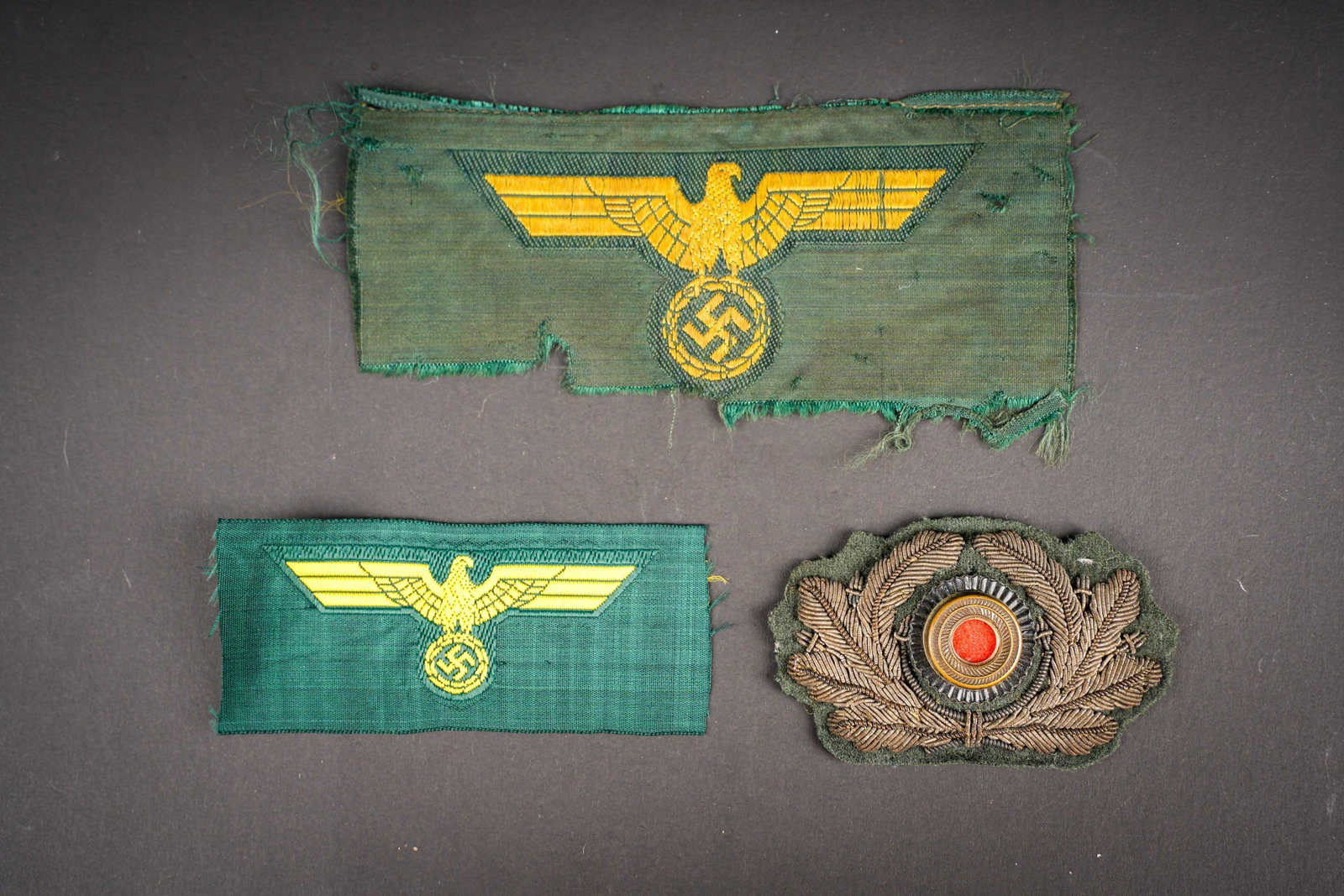 Insignes de l artillerie cotiere. Coastal Artillery insignia.: Insignes de l artillerie cotiere. Comprenant des feuilles de chene de coiffure en cannetille or, sur fond en drap vert fonce. Cocarde metallique, dos de la piece double d un papier blanc. Un aigle de 