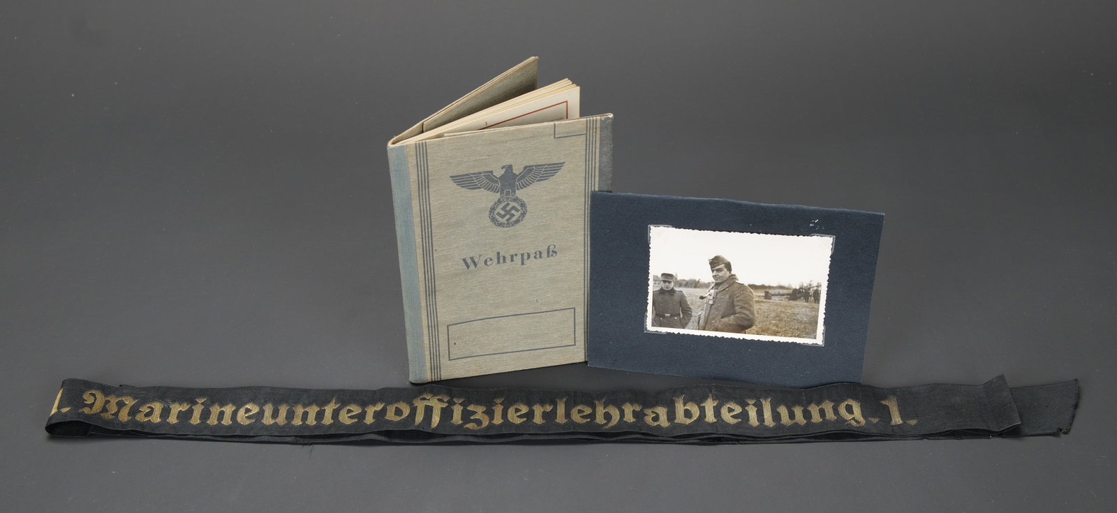 Accessoires Kriegsmarine. German navy accessories.: Accessoires Kriegsmarine. Comprenant une bande de bachi complete, mais presentant des dechirures, marquee 1 Marineunteroffizierlehrabteilung 1. Une photo d un Kriegsberichter, sur son support en epais