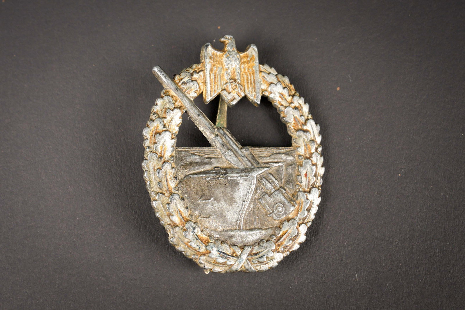 Kriegsabzeichen fur Marineartillerie. German navy insigina: Kriegsabzeichen fur Marineartillerie. En metal. Dorure a 30%. Attache complete. Fabrication Otto Placeck Berlin. A noter une certaine usure et patine de la piece. Etat II+. Marine Artillery War Badge 