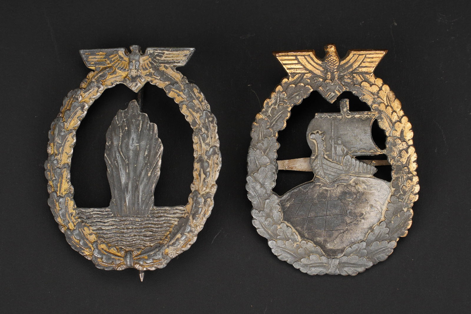 Insignes Kriegsmarine. German Navy insignias: Insignes Kriegsmarine. Comprenant un insigne de mouilleur de mine, dourure a 70%, attache verticale posterieure, sans marquages visibles. Un insigne des croiseurs auxiliaires, dorure a 30%, attache ho