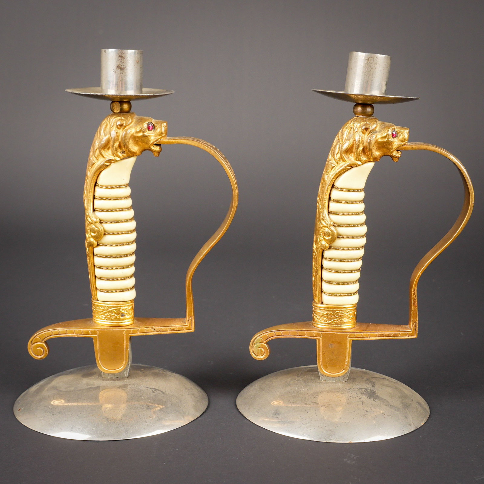 Paire de chandeliers sabres Kriegsmarine. Kriegsmarine candlesticks.: Paire de chandeliers sabres Kriegsmarine. 2 chandeliers realises a partir de sabres d officiers de la Kriegsmarine. Poignee blanche avec filigrane, pommeau tete de lion avec yeux en perles couleur
