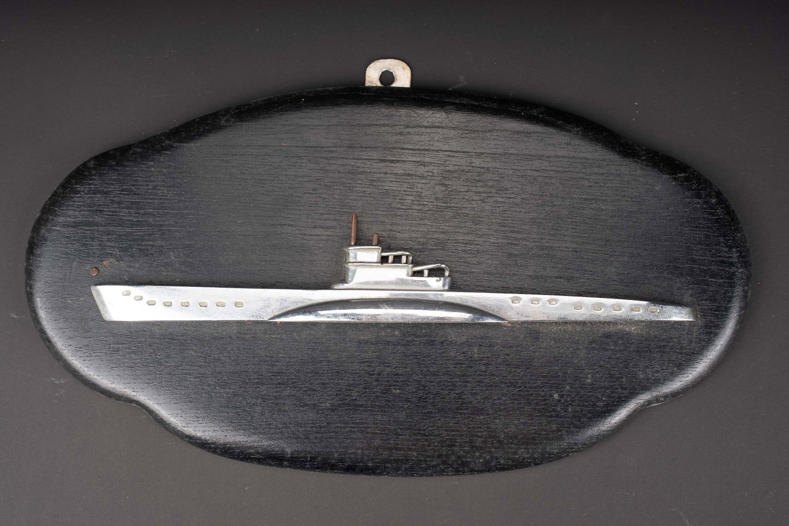 Profil d un sous-marin allemand. German submarine profile.: Profil d un sous-marin allemand. En metal nickele, fixation sur un support en bois. Attache murale complete. Sans marquages visibles. Dimensions 17 x 32 cm. A noter une certaine usure et patine de la