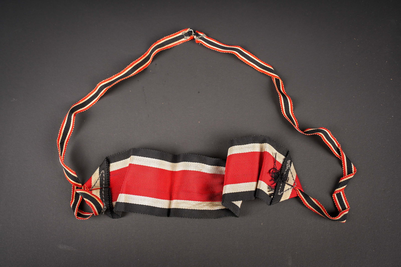 Ruban de Riterkreuz. Knight?s Cross ribbon.: Ruban de Ritterkreuz. En tissu noir/blanc/rouge. Attache presente mais distendue. Sans marquages visibles. L authenticite de la piece n est pas garantie. A noter une certaine usure et patine de la