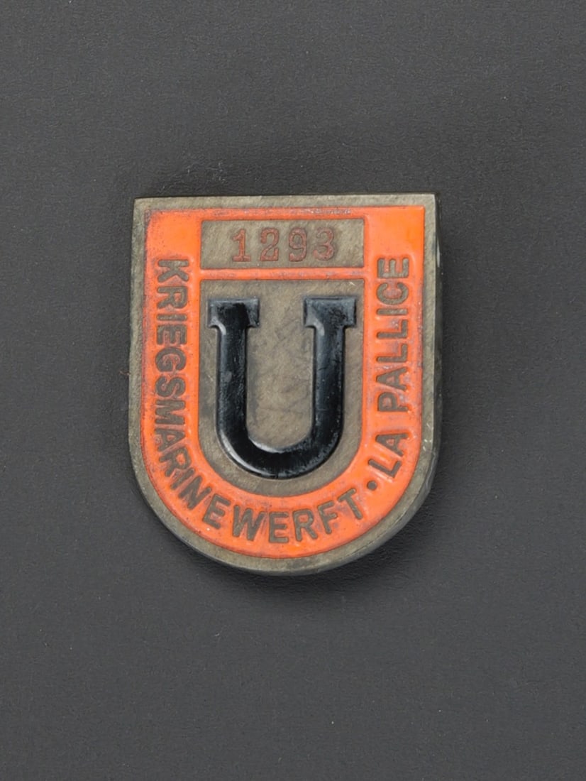 Insigne de la base de sous-marin de La Palice. La Pallice submarine base insignia.: Insigne de la base de sous-marin de La Palice. En metal peint. Marquage Kriegsmarinewerft La Palice, numero 1293. Attache complete. Sans marquages visibles. A noter une certaine usure et patine de la