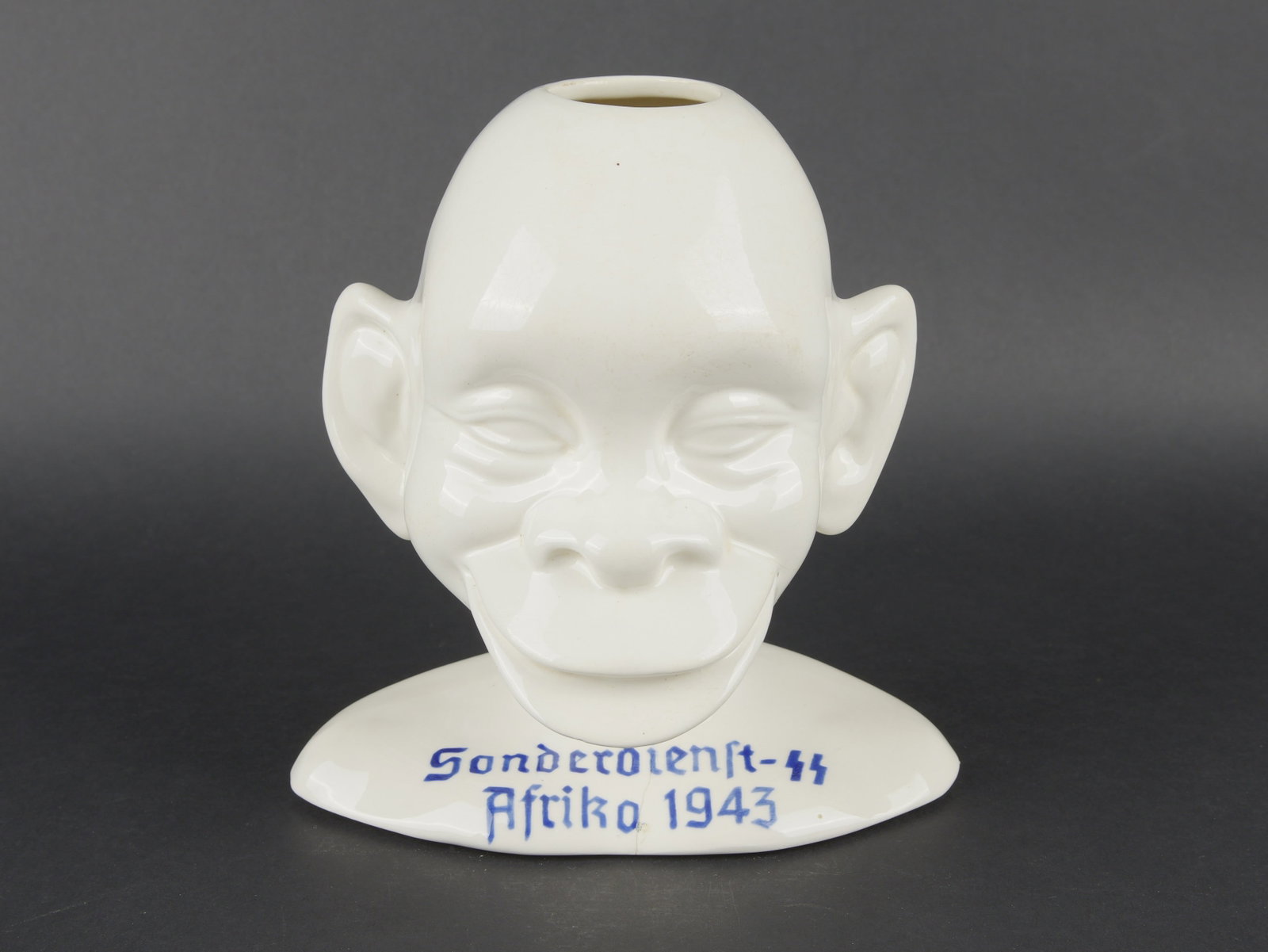 Allach Sonderdienst SS Afrika 1943. Allach Sonderdienst SS Afrika 1943 figurine.: Allach Sonderdienst Afrika SS 1943. Representation d une tete africaine. En porcelaine emaillee blanche. Un creux au niveau du sommet du crane. Marquages bleues Sonderdienst SS Afrika 1943. Quelques