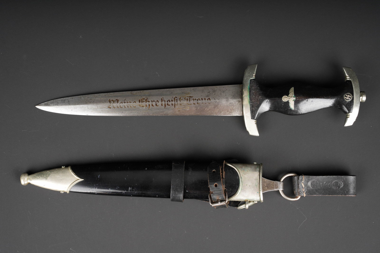 Dague SS. German SS dagger.: Dague SS. Modele 33. Garnitures en metal. Garde portant le numero I. Poignee en bois presentant des manques et des marques d usures. Pastille SS et aigle national allemand, visiblement montes d origin