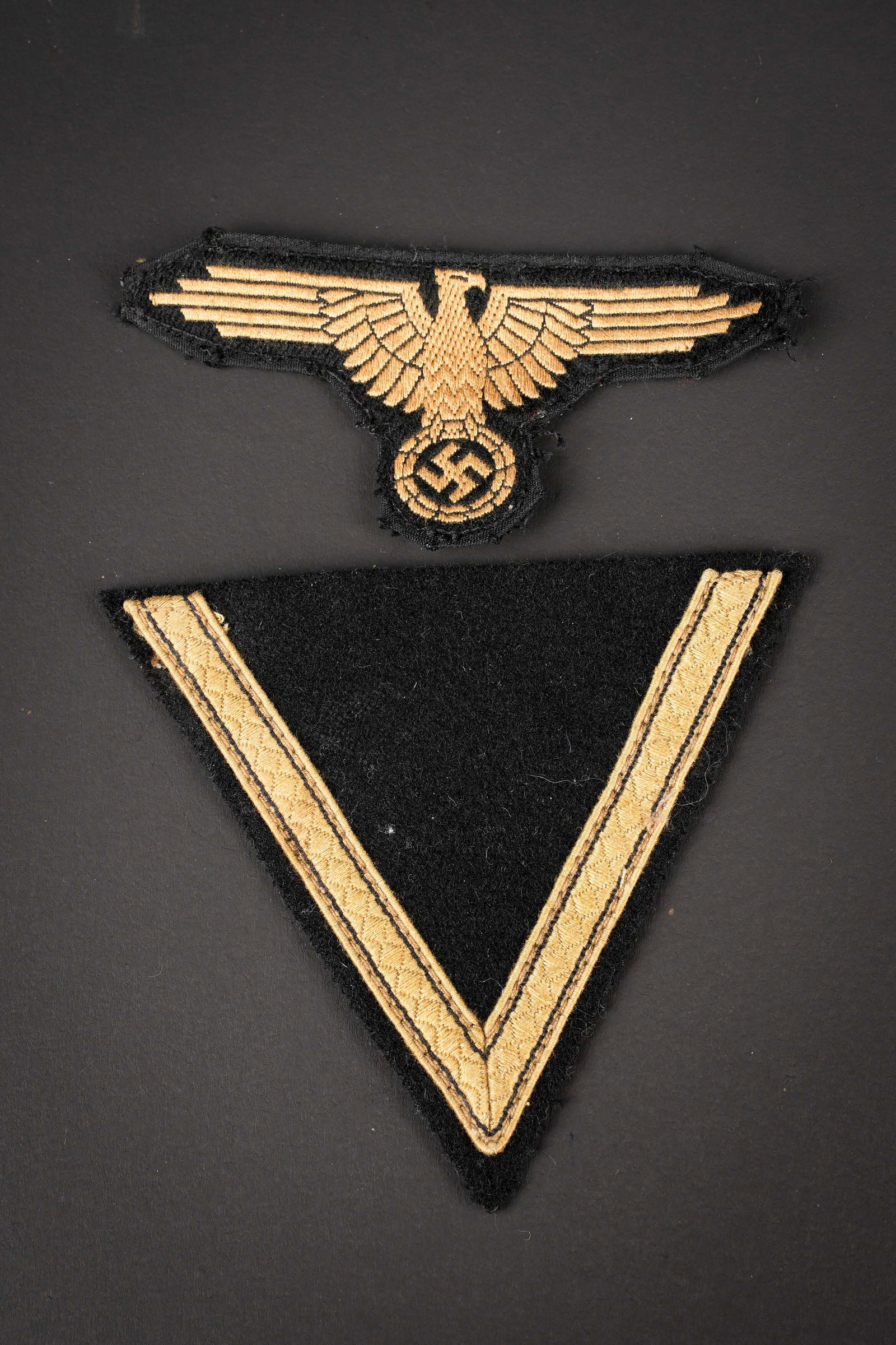 Insignes tropicaux SS. SS tropical insignia.: Insignes tropicaux SS. Comprenant un aigle de bras SS, type tropical Bevo, visiblement demonte d une vareuse. Un grade de manche en drap noir pour Sturmann. A noter une certaine usure et patine des