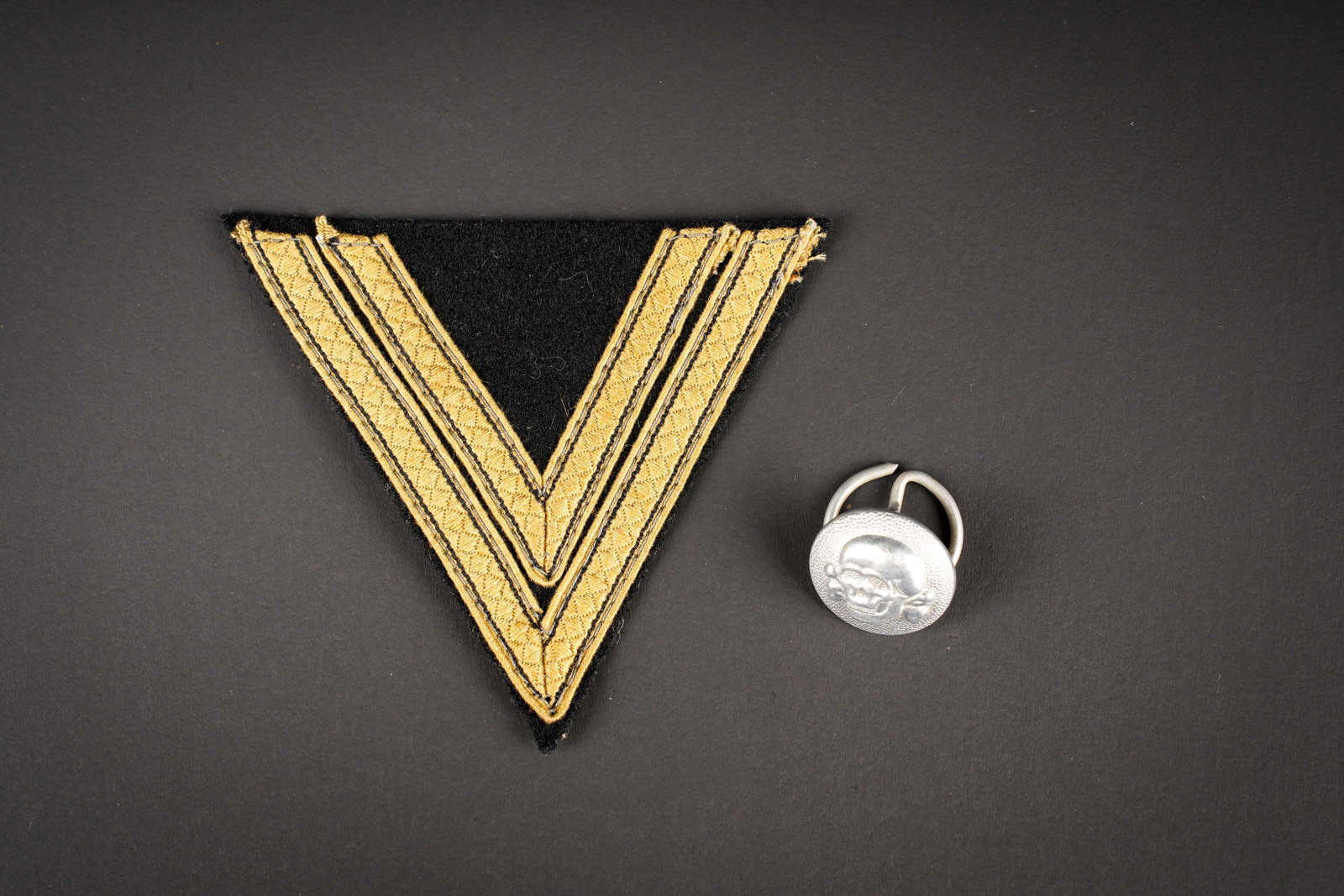 Insignes SS. SS insignia.: Insignes SS. Comprenant une tete de mort pour calot, sous forme de bouton grenele et tete de mort en relief. L anneau grenadiere est present. Fabrication RZM SS 155/38, correspondant au fabricant