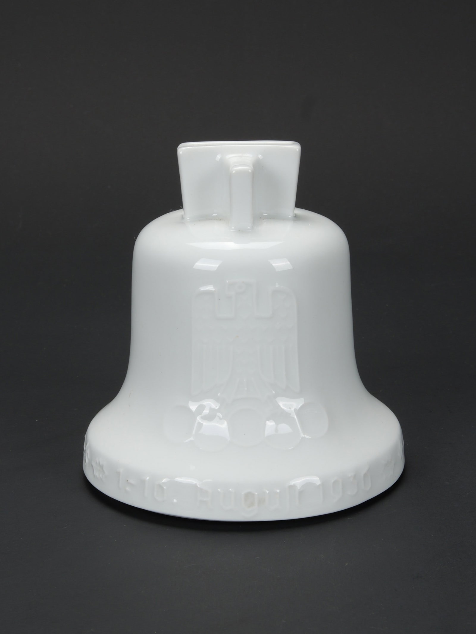 Tirelire Jeux Olympique Berlin 1936.: Tirelire Jeux Olympique Berlin 1936. En porcelaine blanche. Partie superieur disposant d une encoche pour y inserer les pieces. Marquages 1-10 august 1936 10 Olympische Spiele Berlin. Couvercle en