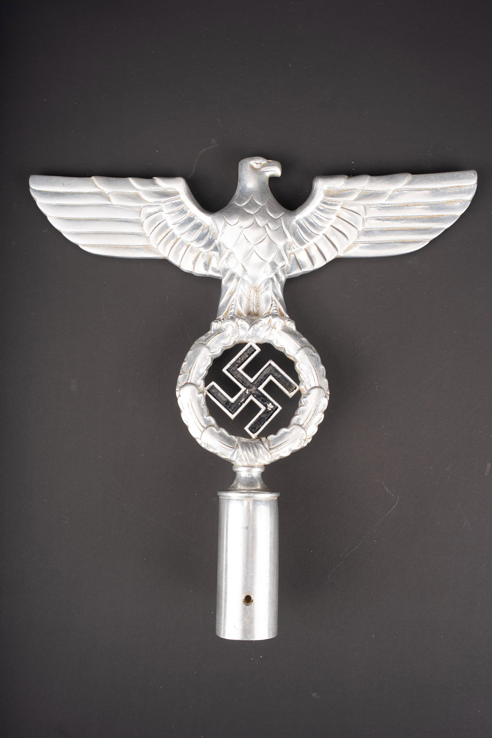 Pointe de drapeau NSDAP. NSDAP flag finial.: Pointe de drapeau NSDAP. En metal, couleur argent. Couleur noir de l insigne national a 80%. Bel aigle aux ailes deployees. Fabrication RZM M3/34/35. Dimensions 25,5 x 25 cm. A noter une certaine
