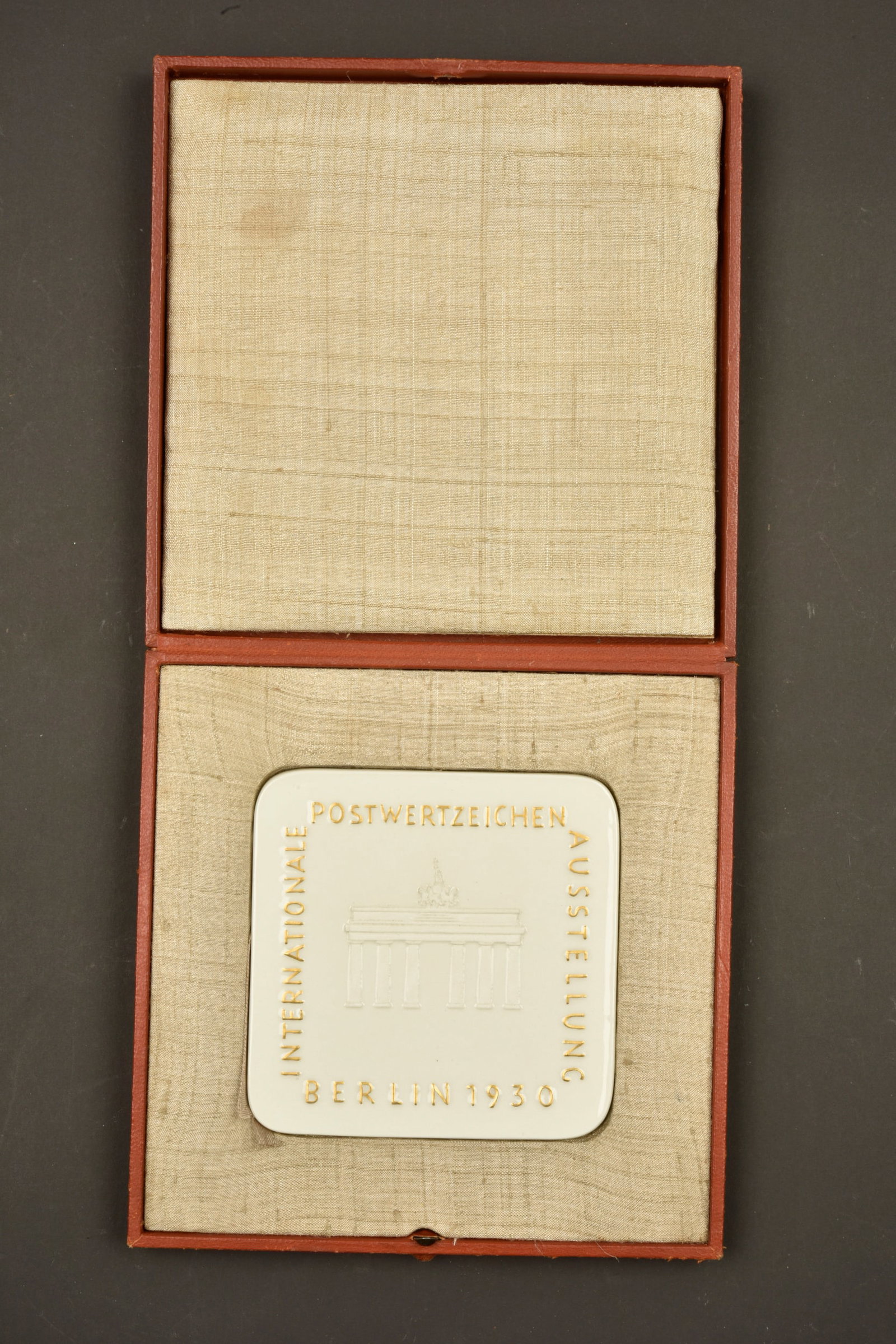 Plaquette Postwertzeichen Austellung 1930. Postwertzeichen Ausstellung 1930 commemorative plaque.: Plaquette Postwertzeichen Ausstelung Berlin 1930. En porcelaine blanche, fabrication KMP Meissen. Recto marque International Postwertzeichen Ausstellung Berlin 1930, avec un beau decors de la porte
